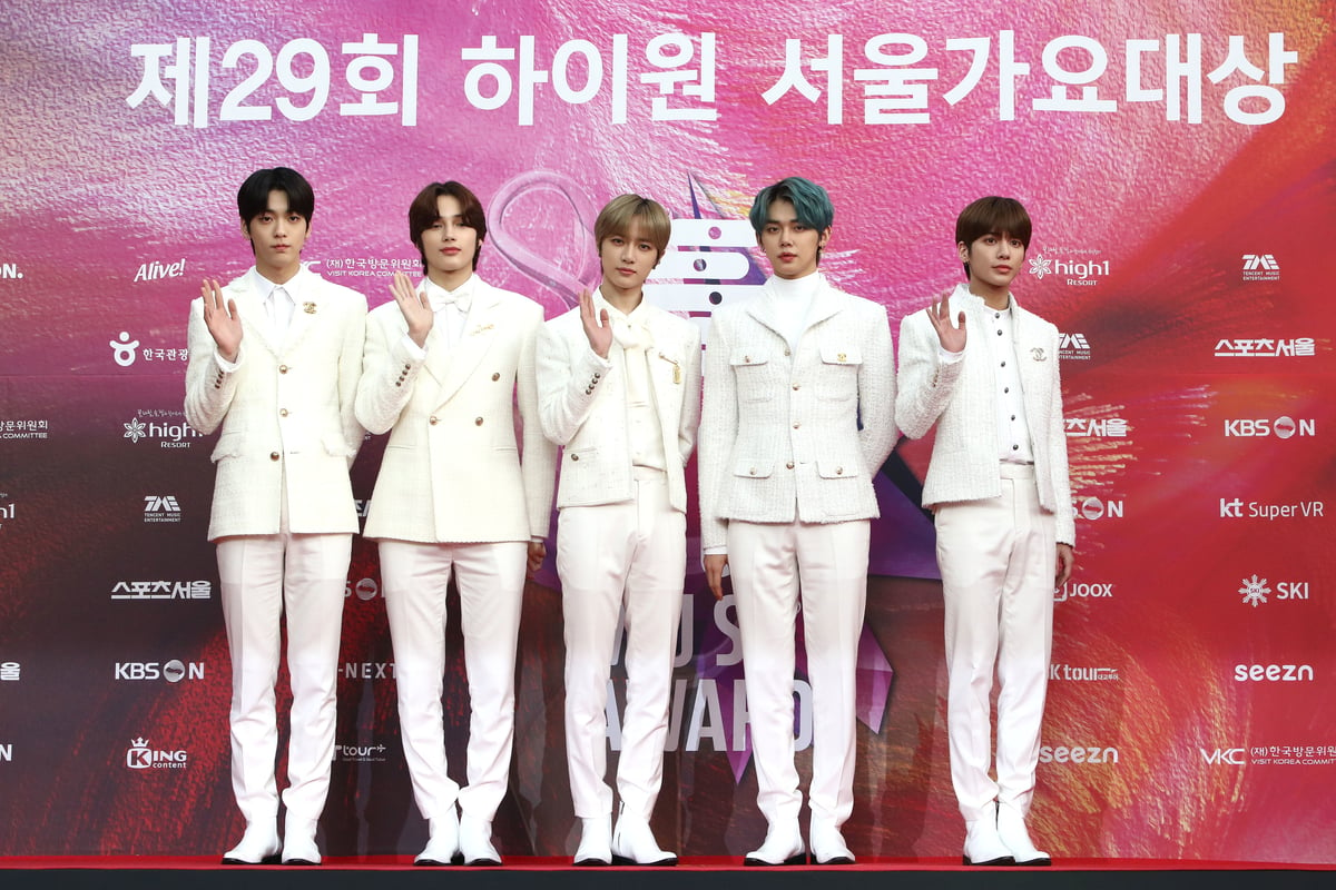 Wearing white suits, the members of TOMORROW X TOGETHER pose on the red carpet of the Seoul Music Awards in Seoul, South Korea.