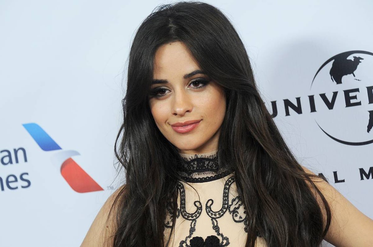 Camila Cabello smiles and poses at an event.