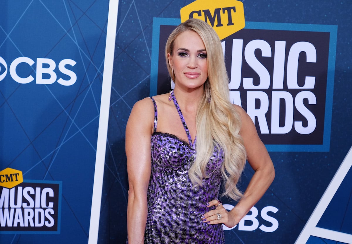 'American Idol' winner Carrie Underwood poses in a purple dress at an event.