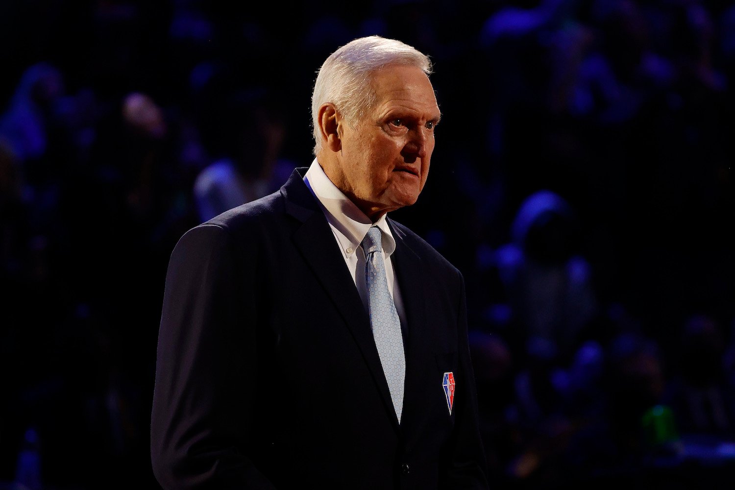 Jerry West standing in a suit on stage