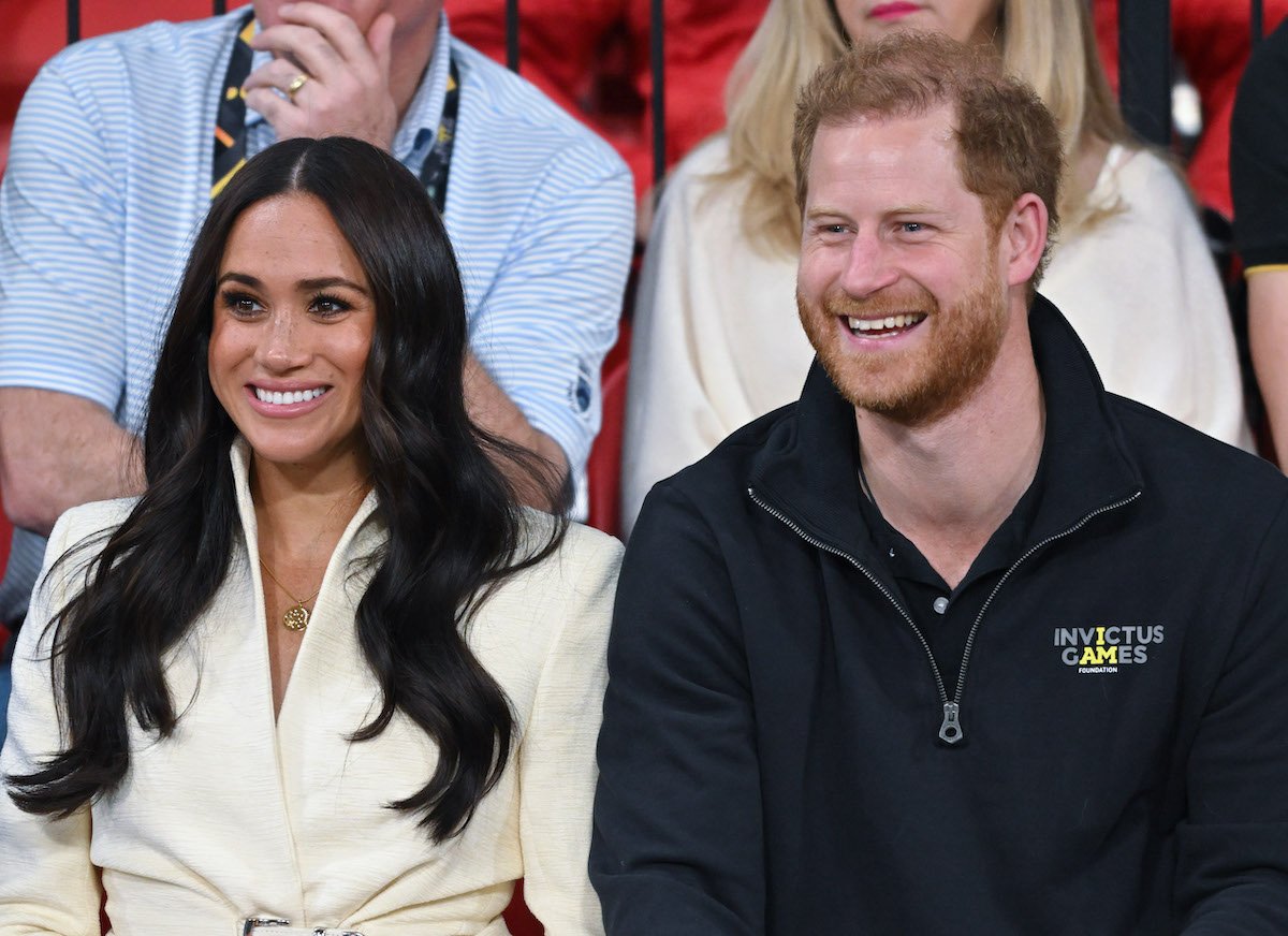 Meghan Markle and Prince Harry, whose Platinum Jubilee visit is likely to make other royals resent them, according to an expert, smile and look on