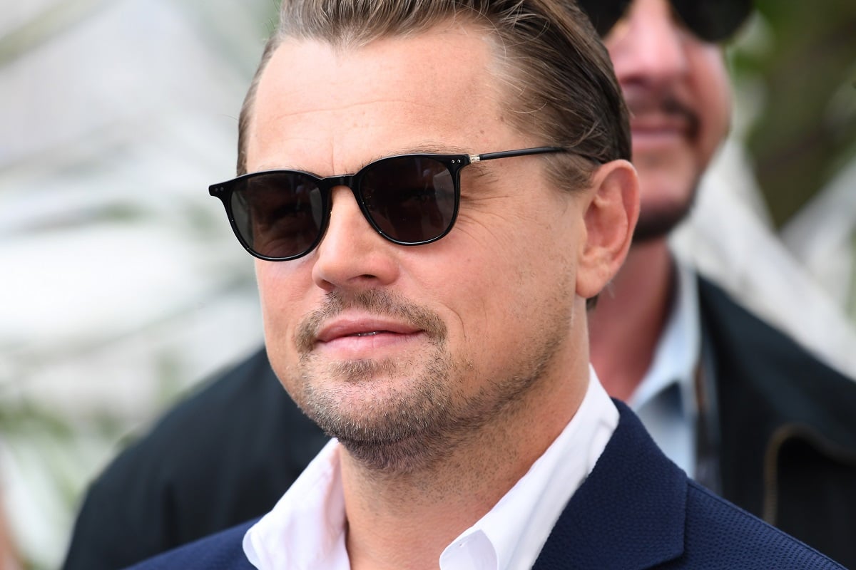 Leonardo DiCaprio smirking while wearing sunglasses.