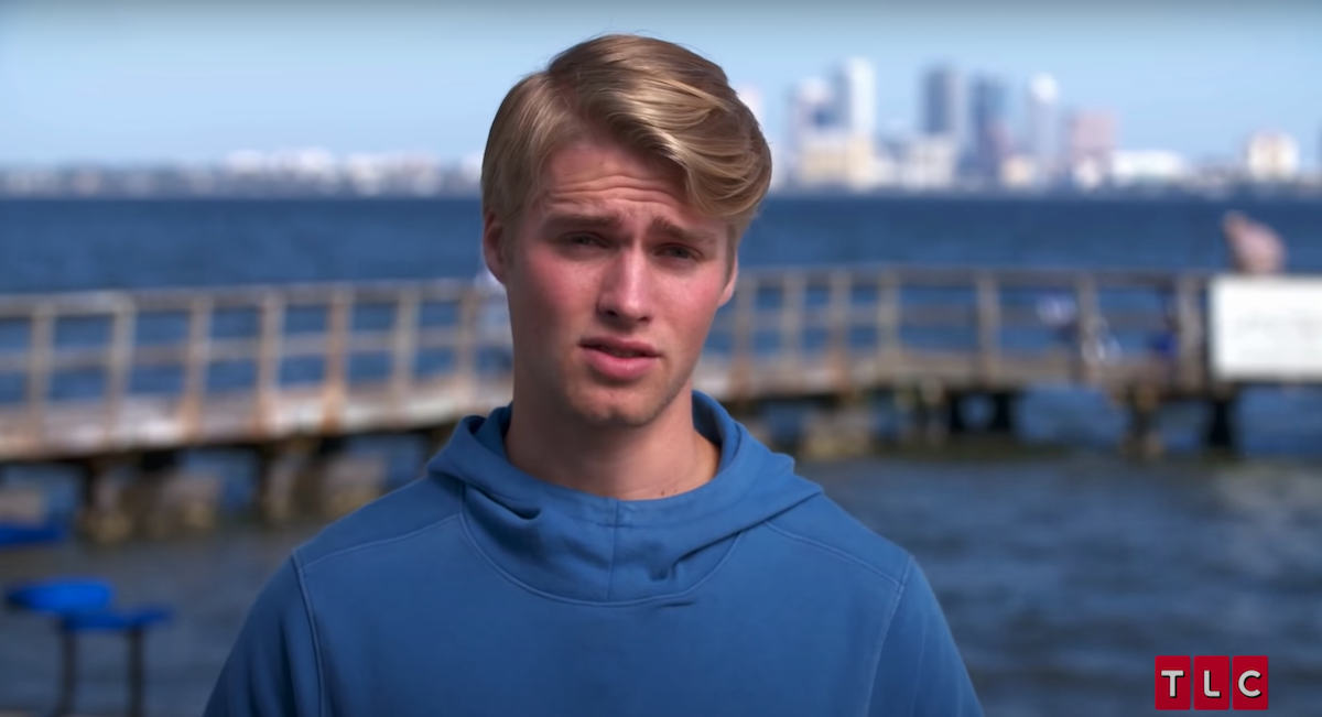 Micah Plath standing in front of pier in episode of 'Welcome to Plathville'