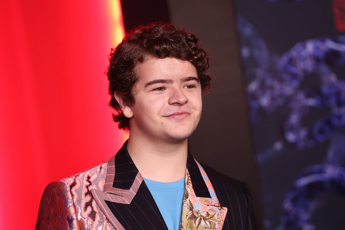 Gaten Matarazzo attends Netflix's Stranger Things Season 4 premiere wearing a patterned jacket and blue shirt underneath. 