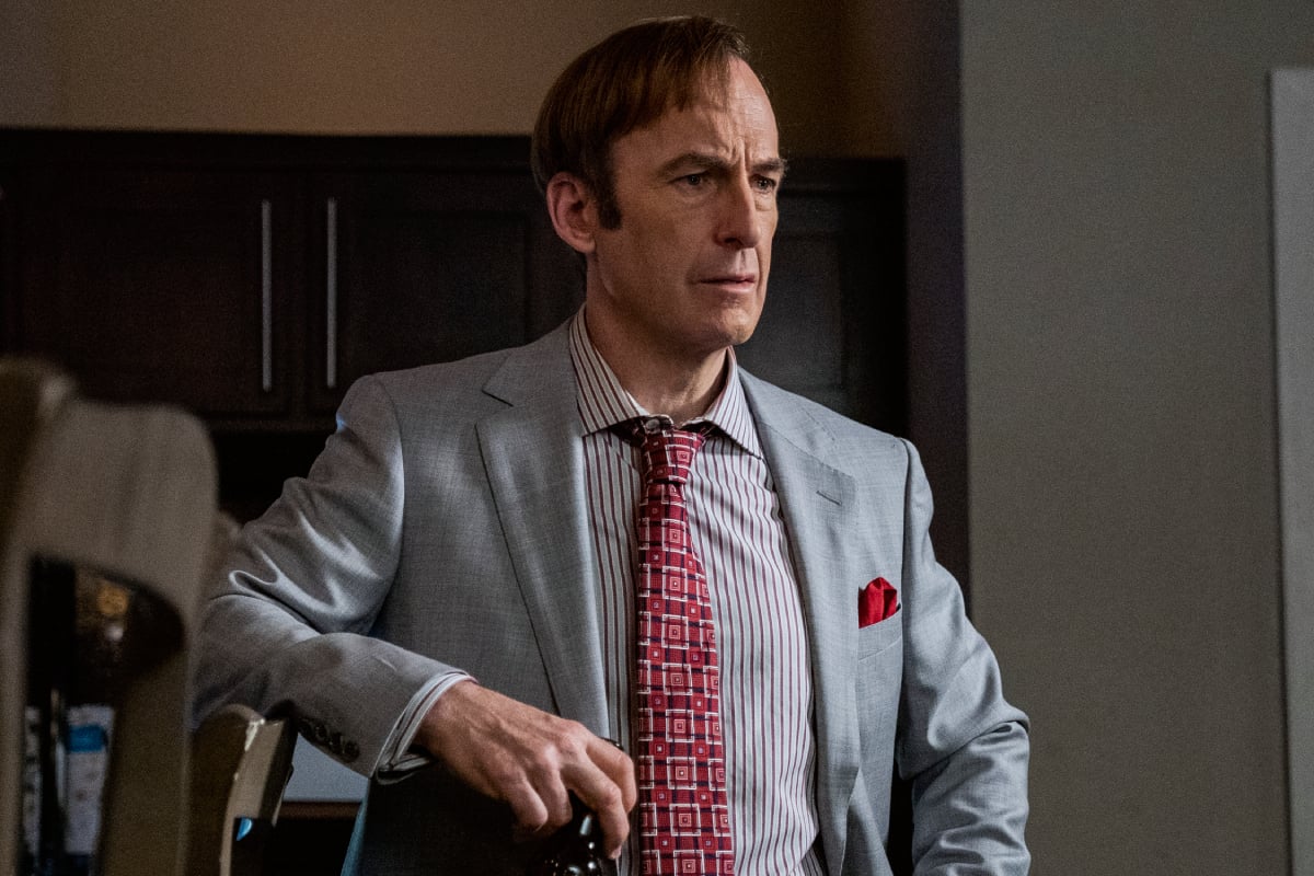 Bob Odenkirk as Saul Goodman in Better Call Saul Season 6. Saul wears a grey suit and red tie. 