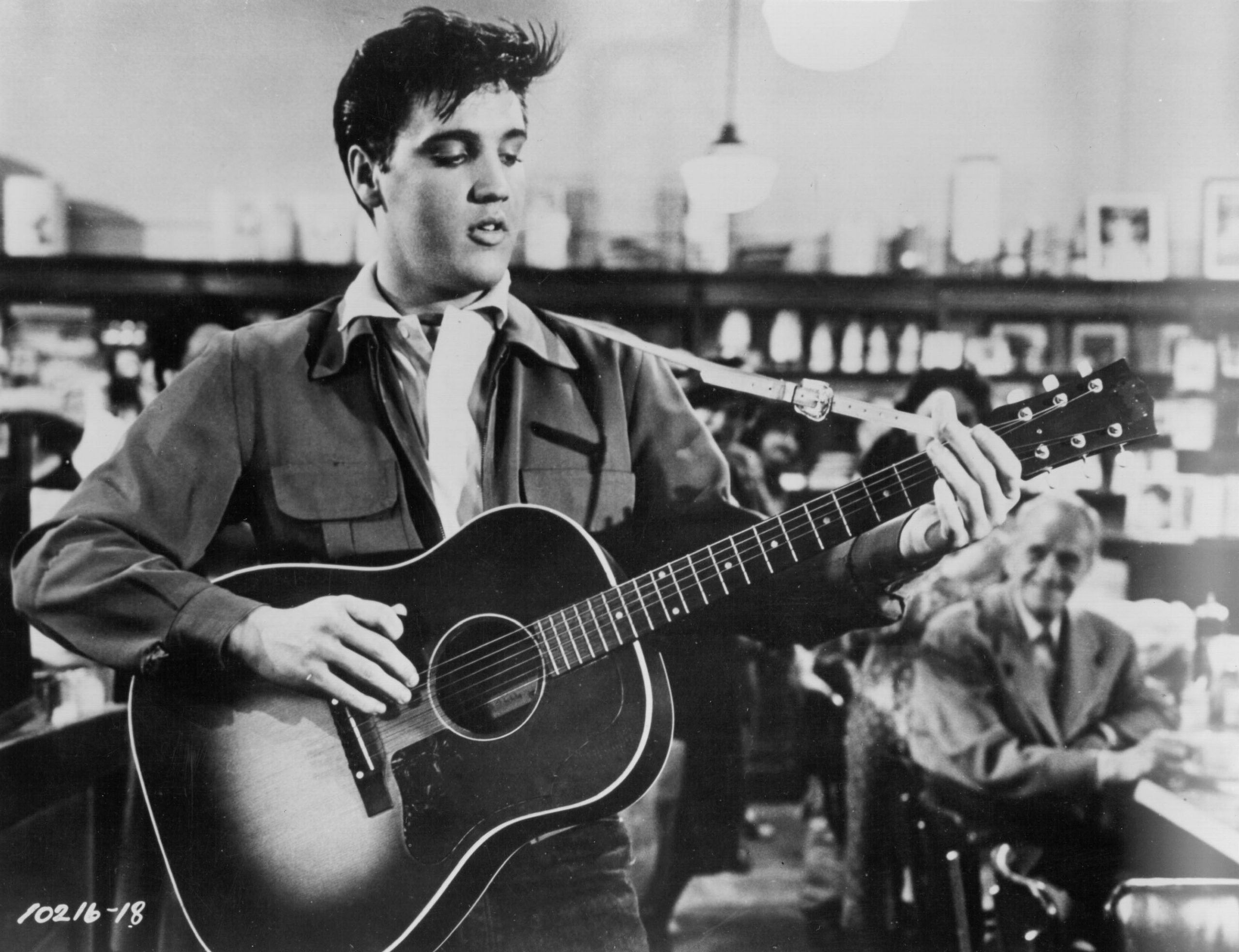 Elvis Presley playing songs on a guitar