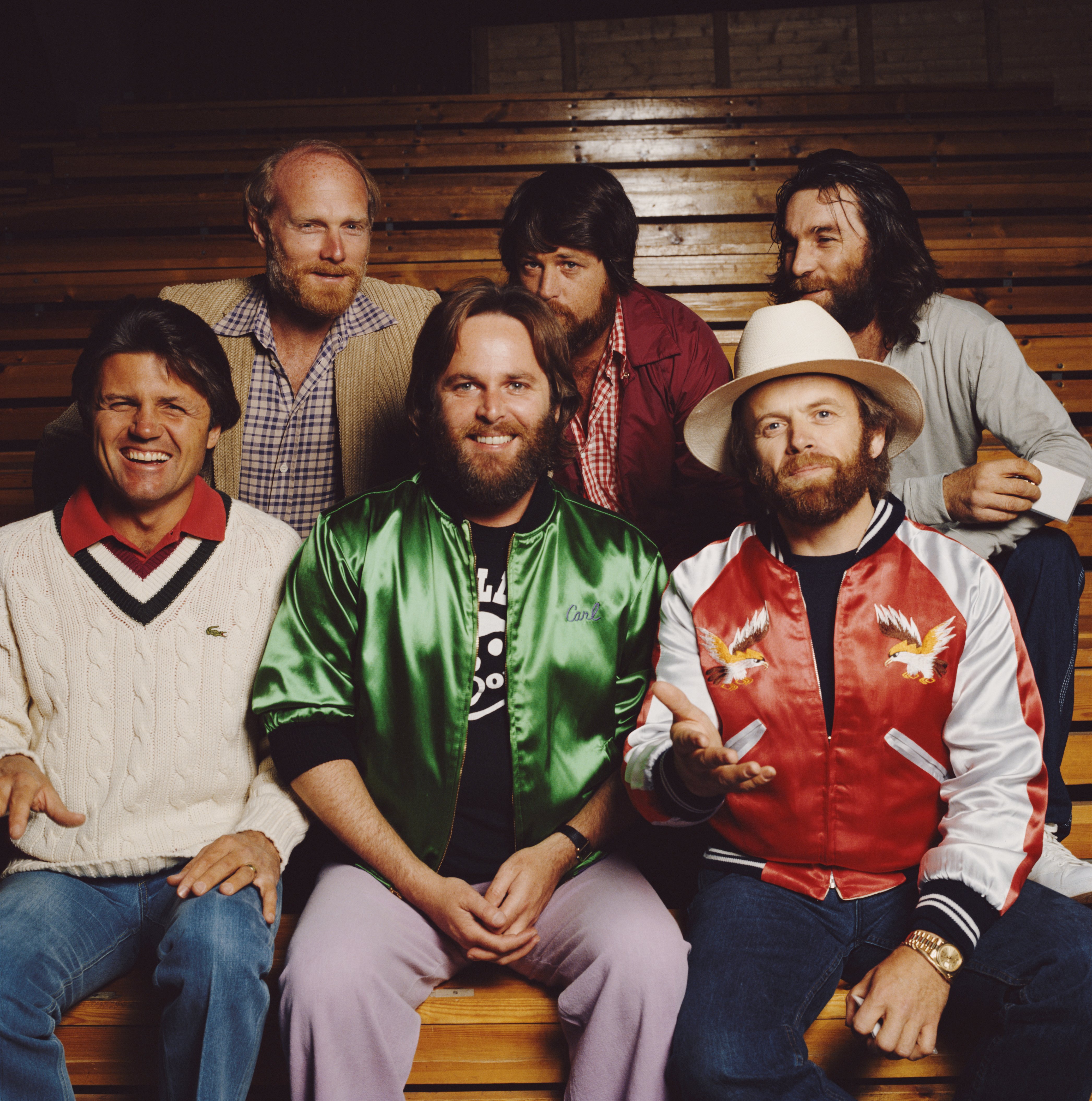 The Beach Boys sitting on bleachers