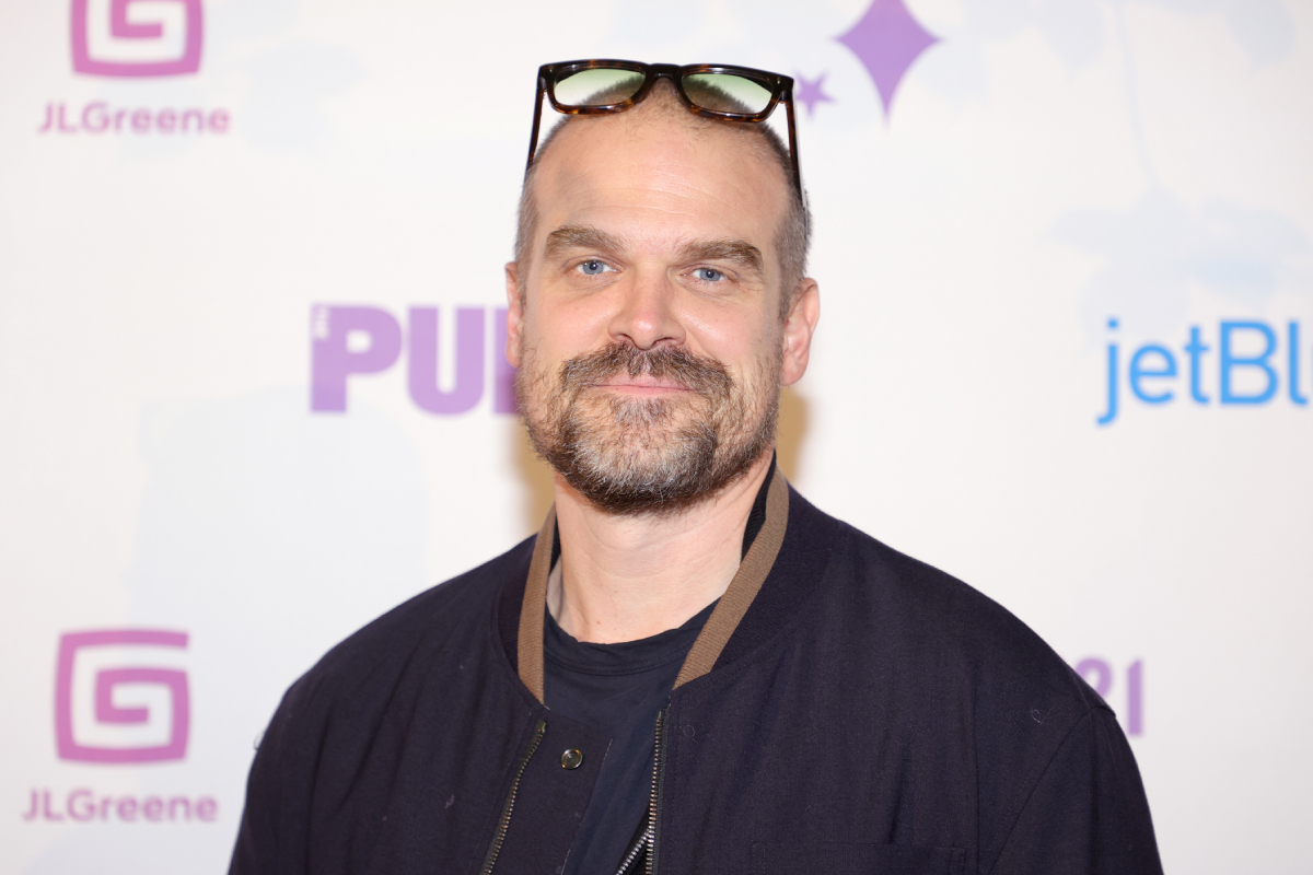 Stranger Things actor David Harbour attends the Public Theater's 2021 annual Gala at the Delacorte Theater in Central Park on September 20, 2021 in New York City. Harbour wears a black jacket and shirt and glasses on his head. 