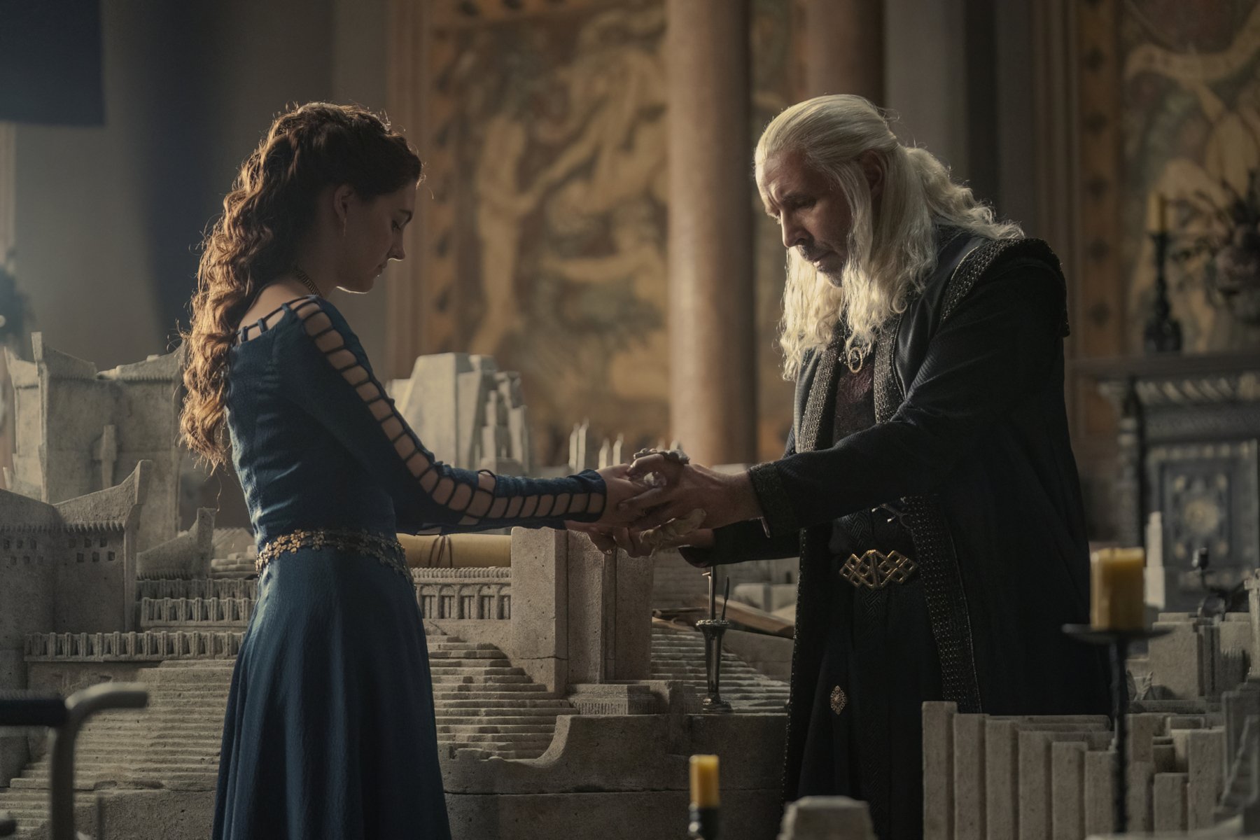 Emily Carey and Paddy Considine as Alicent Hightower and King Viserys in 'House of the Dragon,' which airs episode 3 on Sept. 4. The two are facing one another and holding each other's hands.