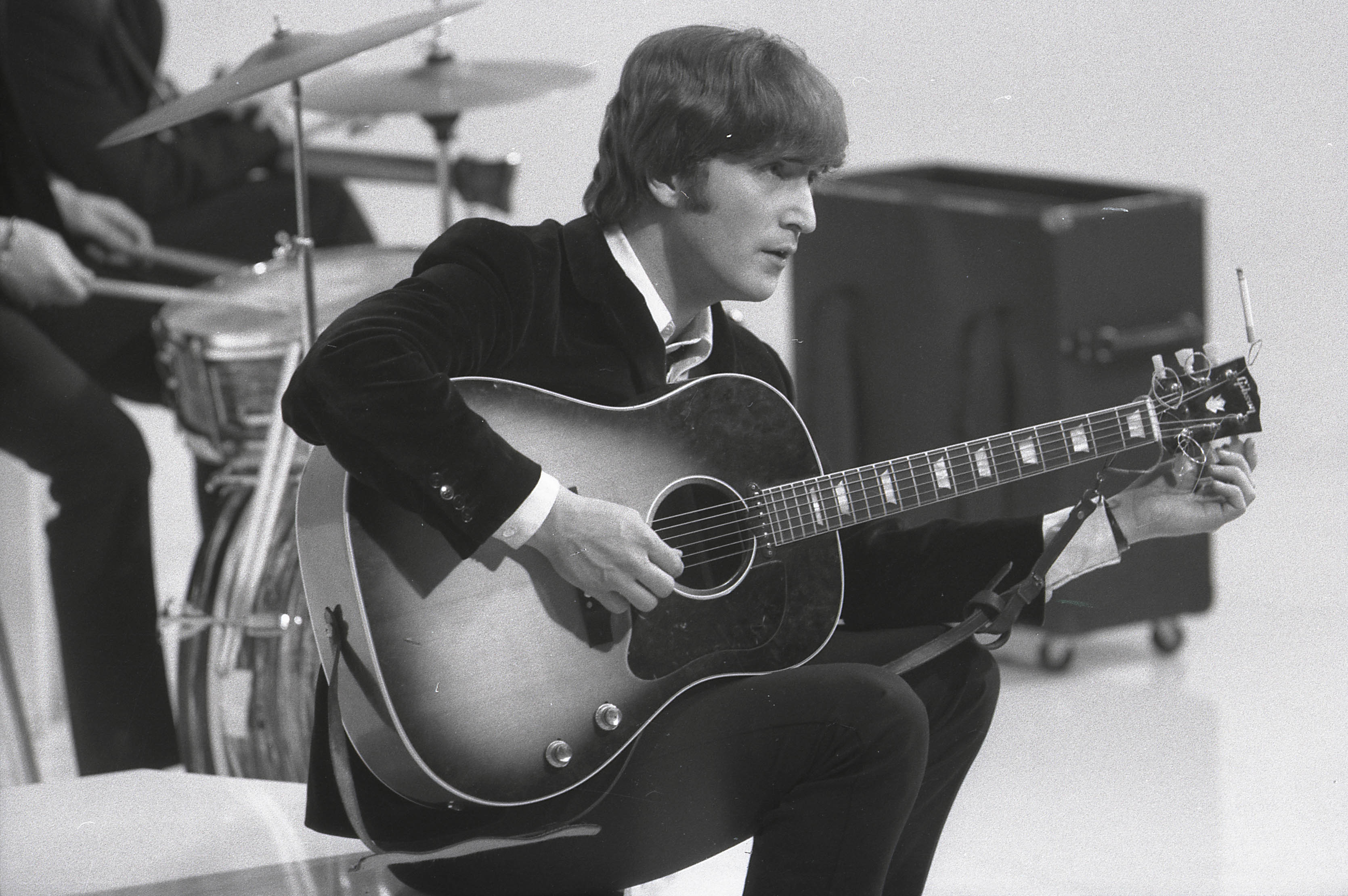 John Lennon holding a guitar during The Beatles' 'Sgt. Pepper' era