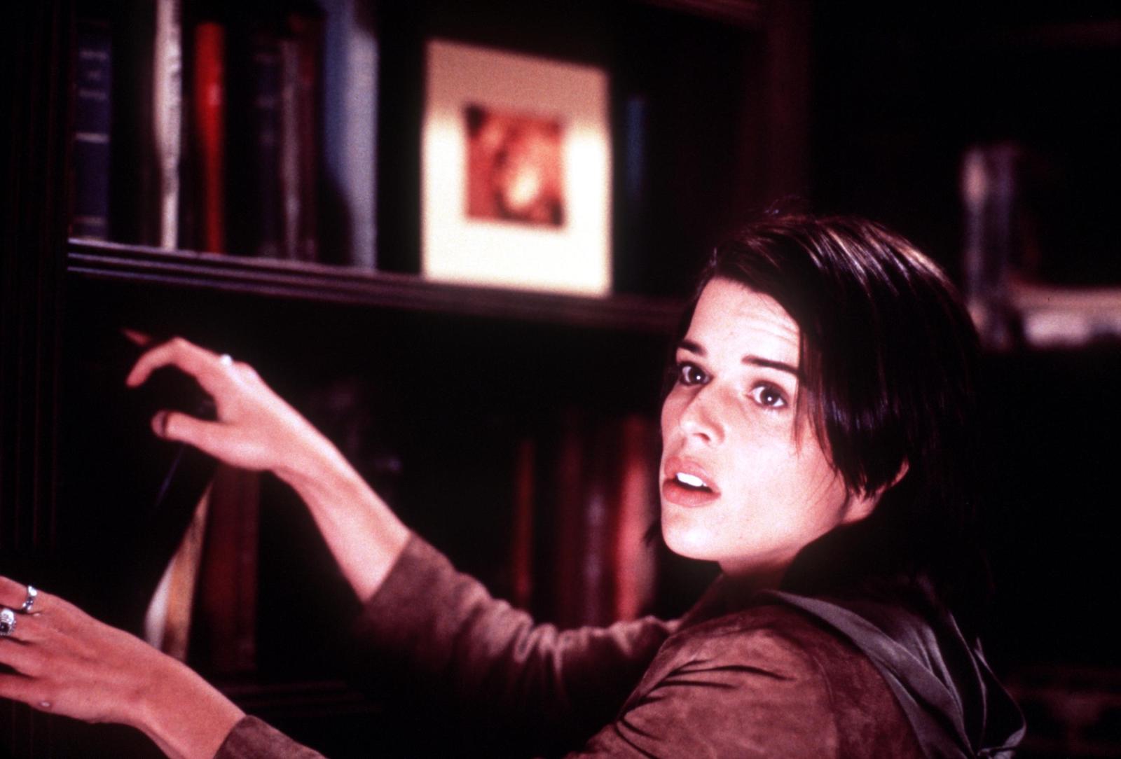 Neve Campbell looks over her shoulder while in character during the filming of 'Scream.'