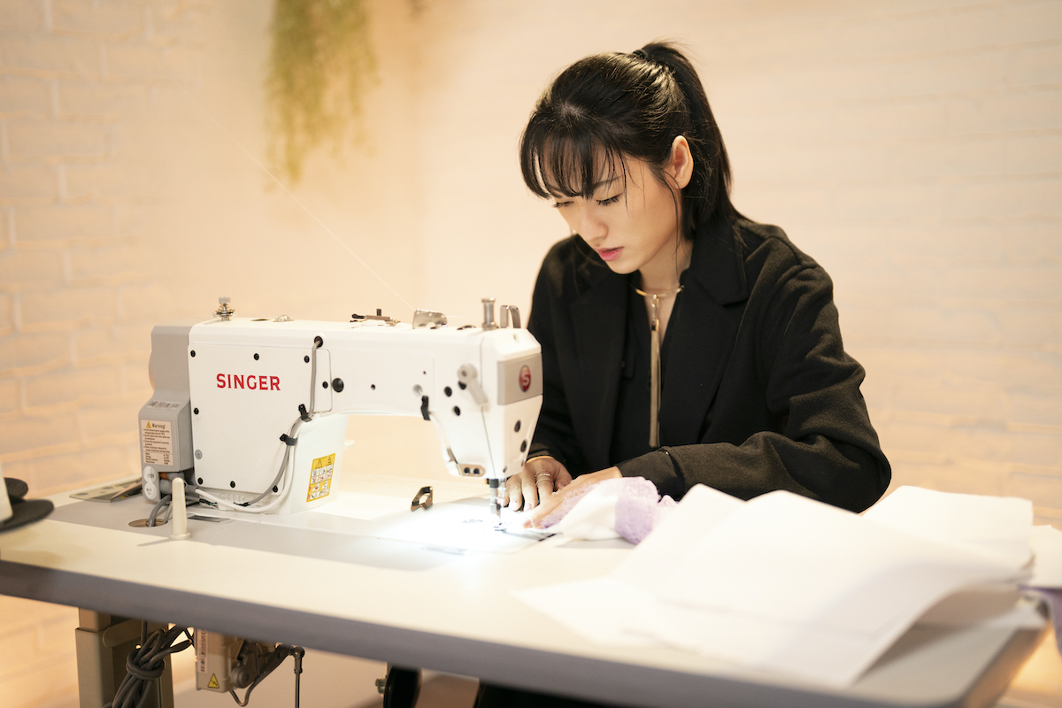 Sienna Li working at her sewing machine in 'Making the Cut' Season 3