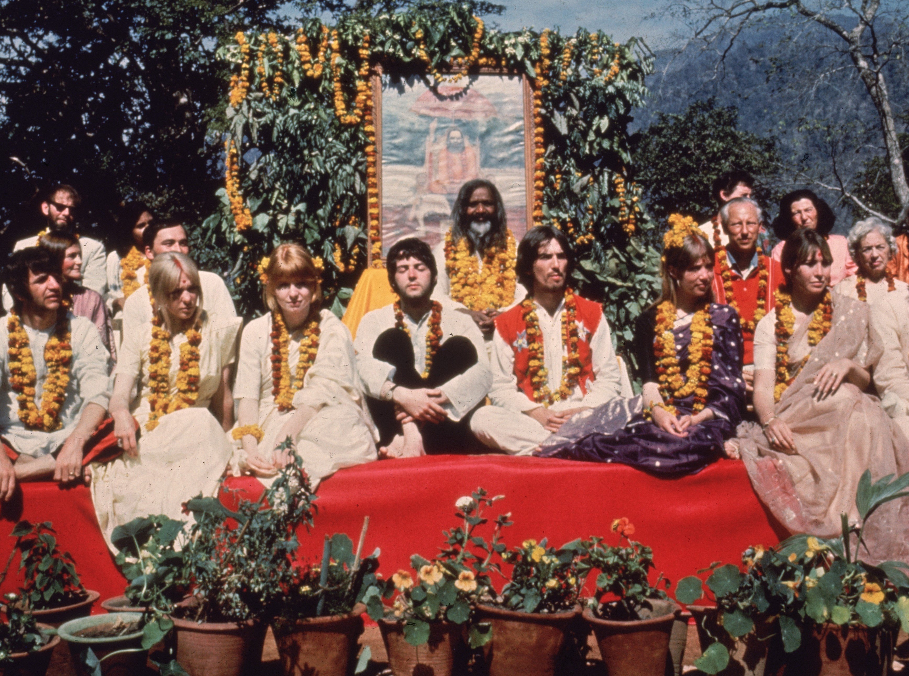 The Beatles' Paul McCartney, George Harrison, Maharishi Mahesh Yogi, and others near plants