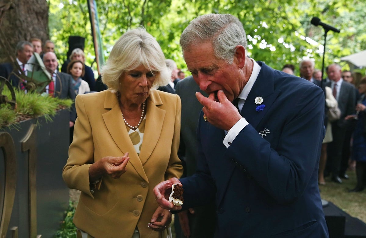 Camilla Parker Bowles and now-King Charles eating cake as they celebrate the 21st anniversary of Duchy