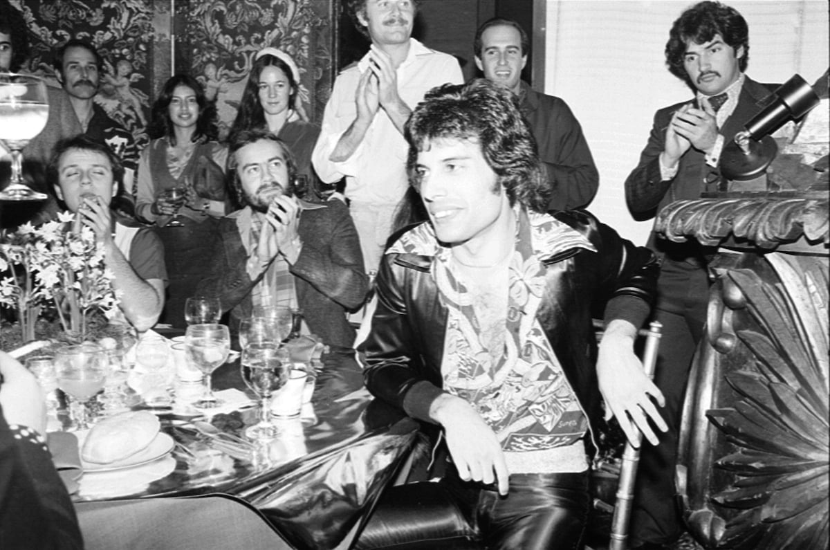 Freddie Mercury of Queen sits at a table during a 1970 event