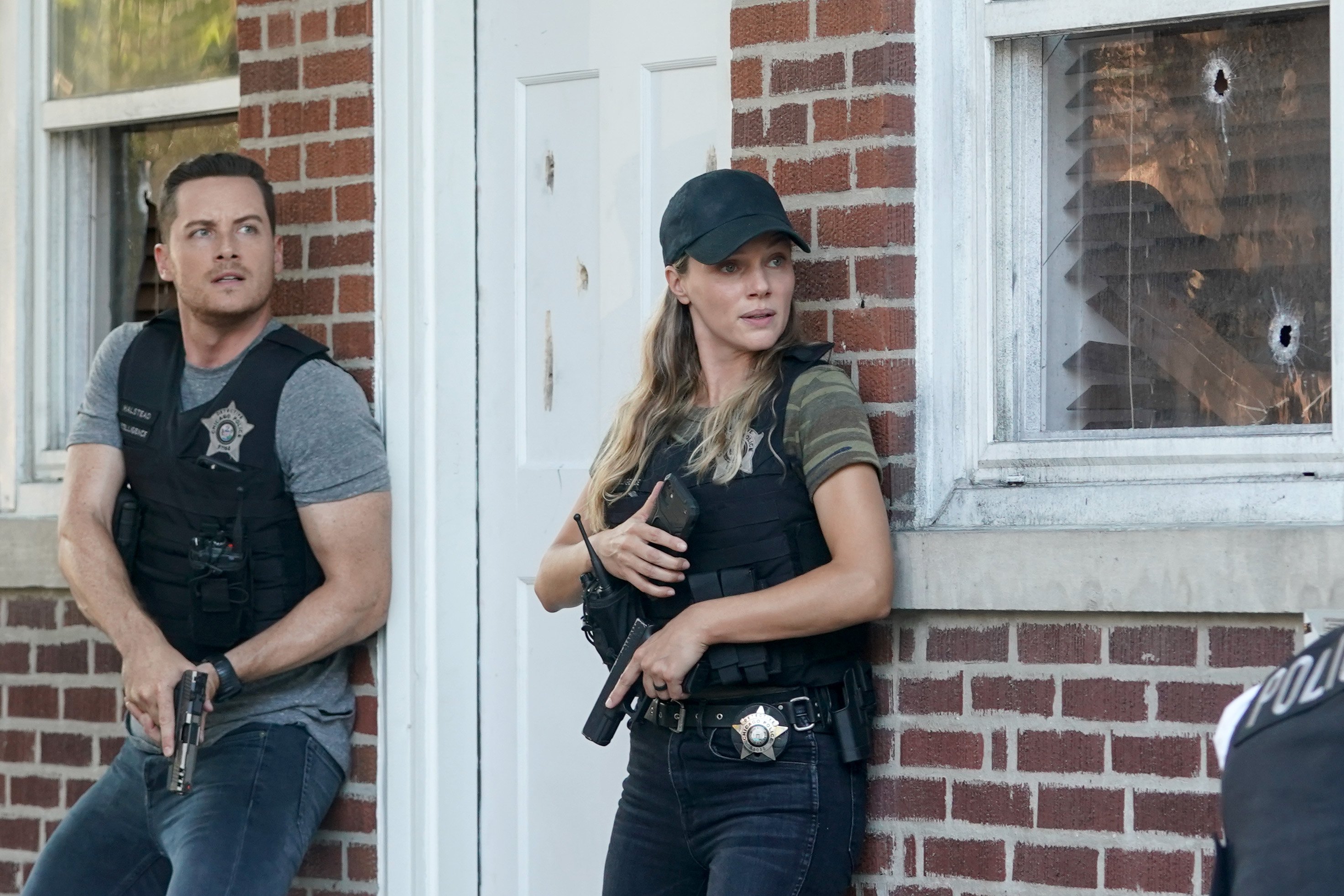 Halstead and Upton standing outside a house with guns drawn in 'Chicago P.D.' Season 10 premiere