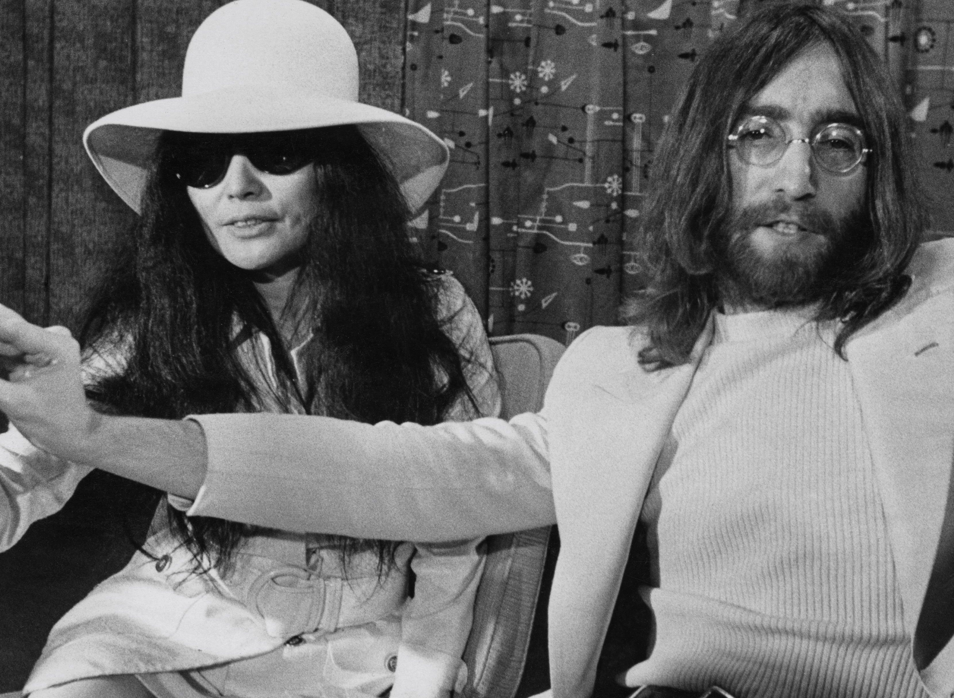 Yoko Ono and John Lennon in front of a curtain