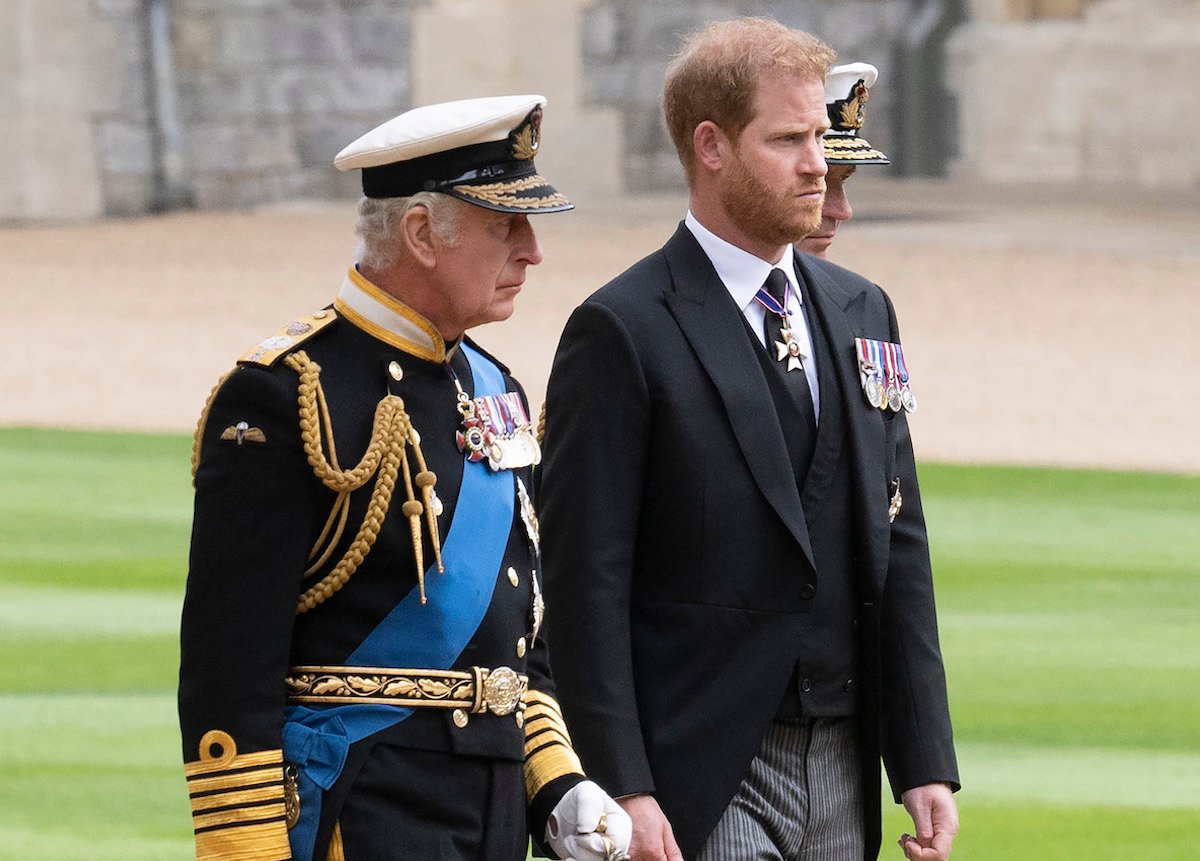 King Charles, who may benefit from Prince Harry's memoir, according to a royal commentator, walks next to Prince Harry at Queen Elizabeth's funeral