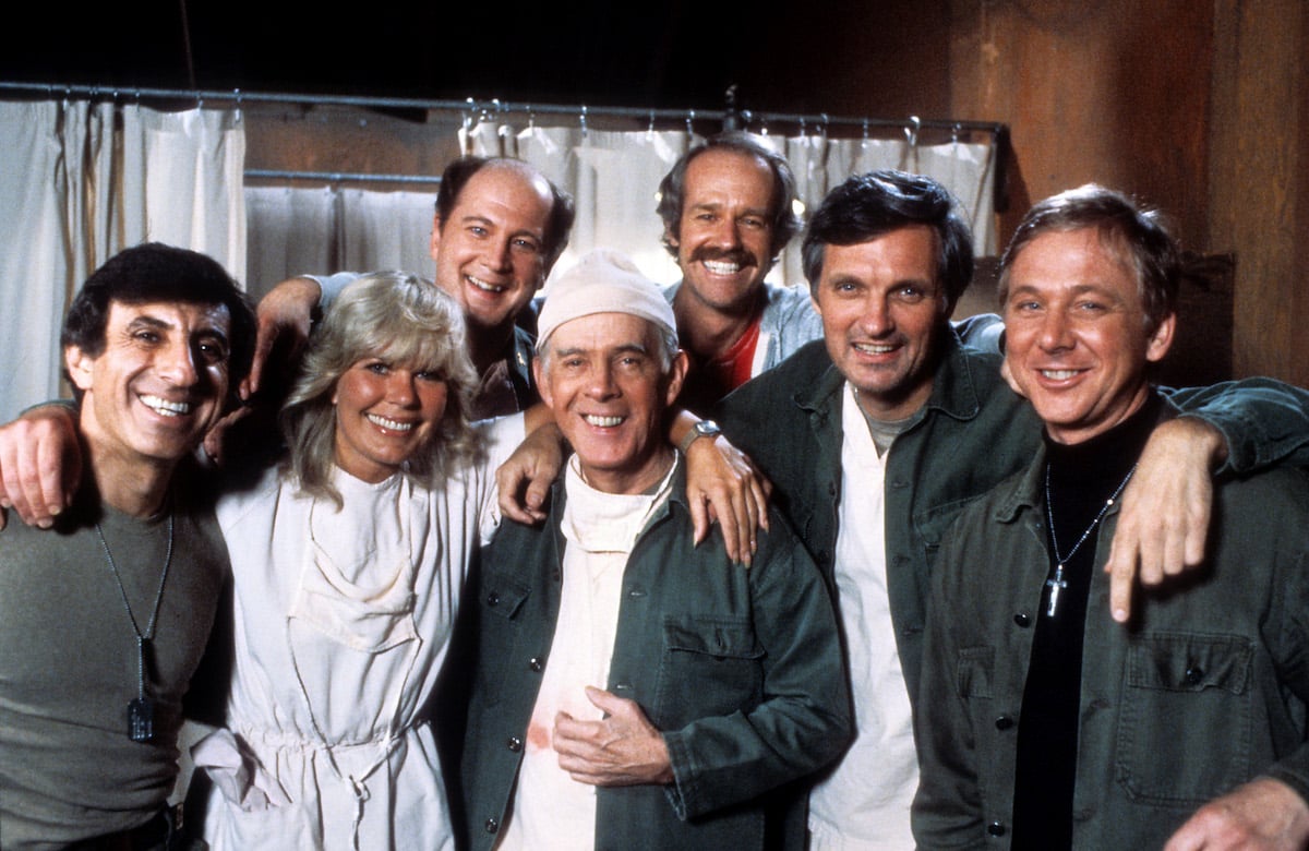 Jamie Farr, Loretta Swit, David Ogden Stiers, Harry Morgan, Mike Farrell, Alan Alda, and William Christopher pose for a portrait while filming 'M*A*S*H' in 1978