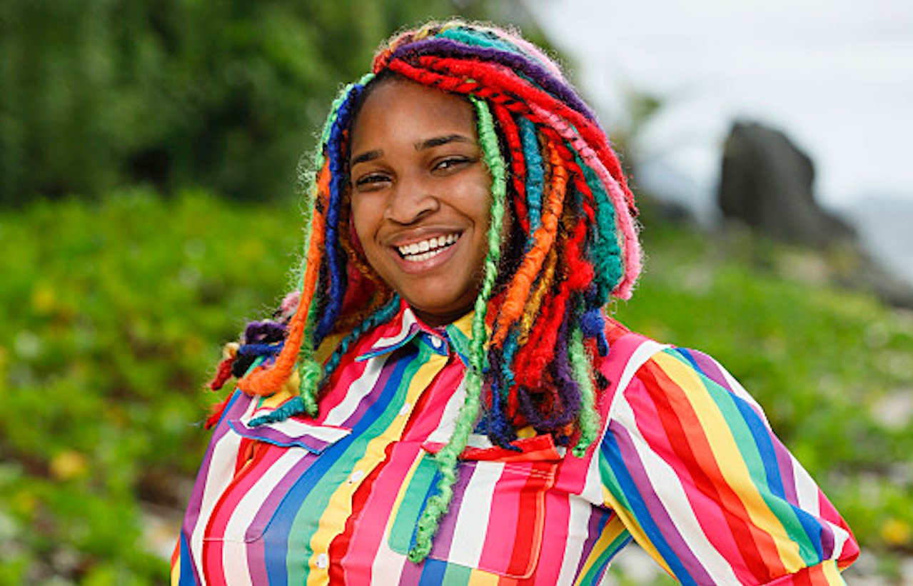 Morriah Young poses on the beach in a rainbow striped dress for 'Survivor 43'.