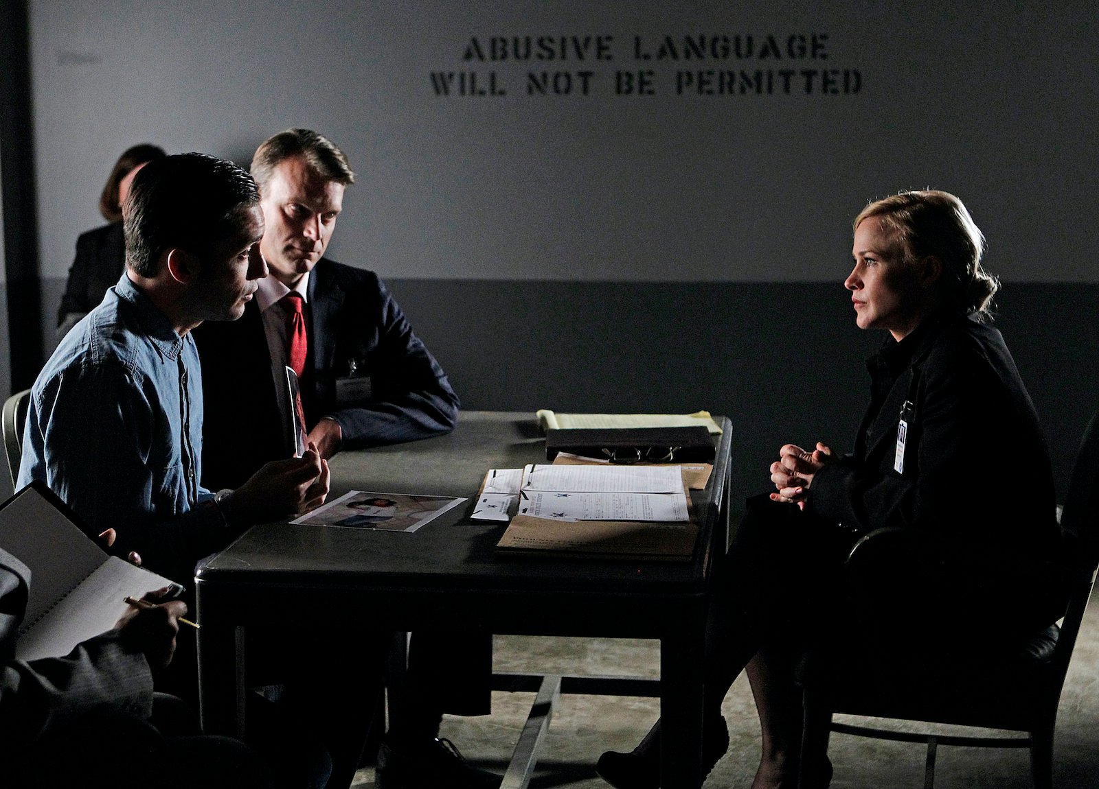 Emmy Award winning actor Patricia Arquette sits across the table from two men in the series 'Medium'