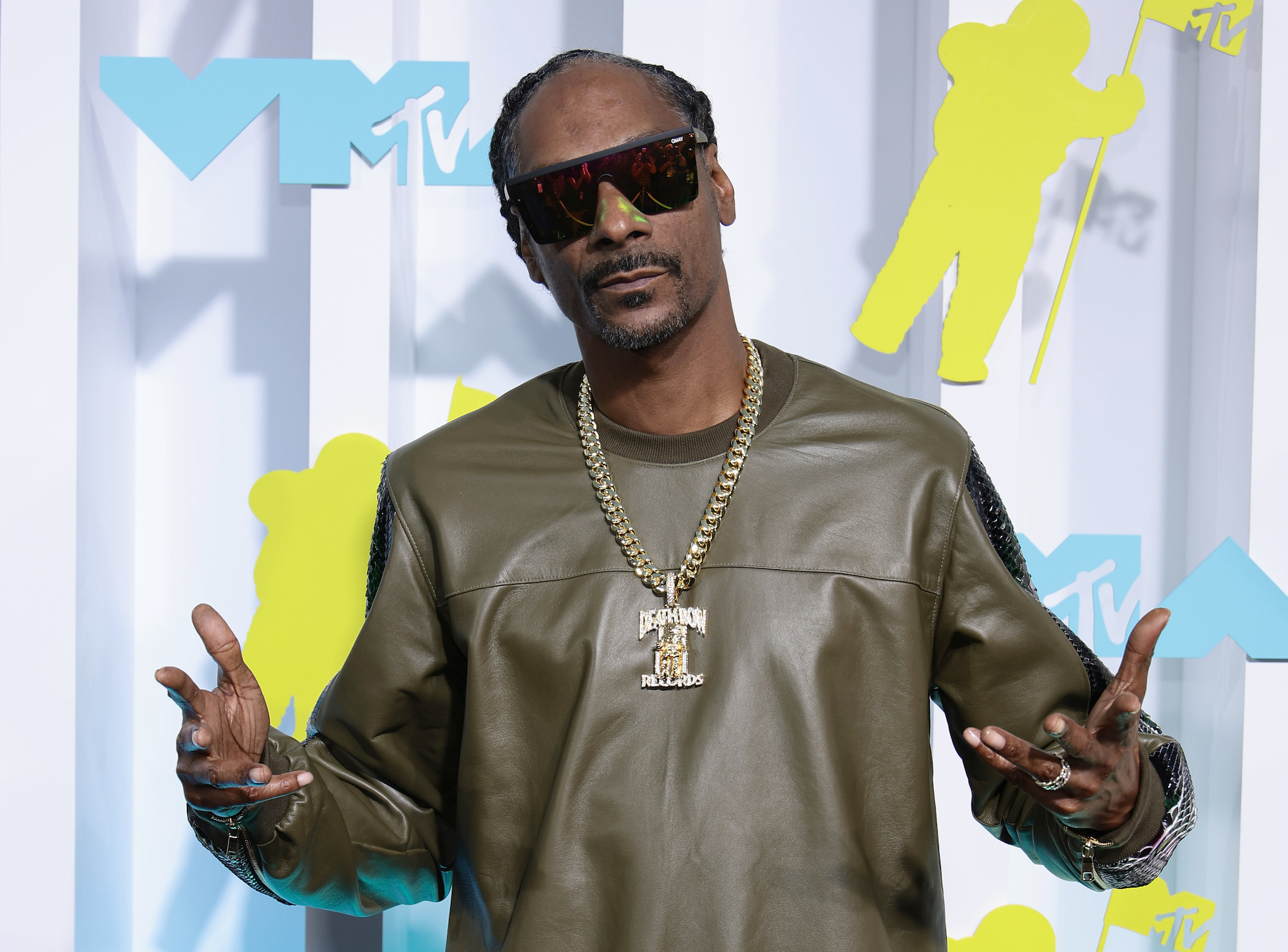 Snoop Dogg, who will have his own Funko store, wearing green and posing for a photo.