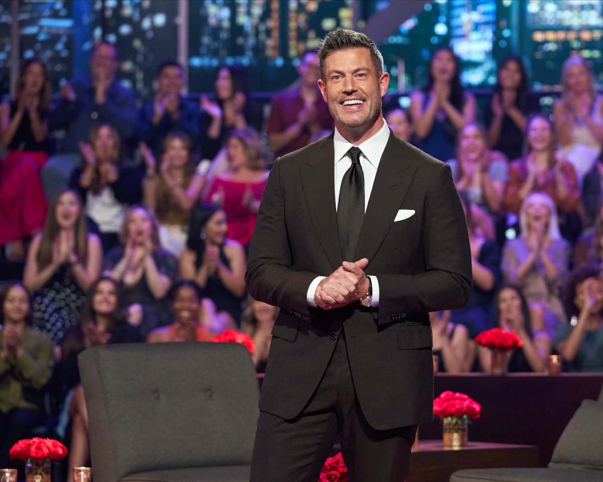 The Bachelorette host Jesse Palmer stands in front of an applauding crowd at the Men Tell All. 