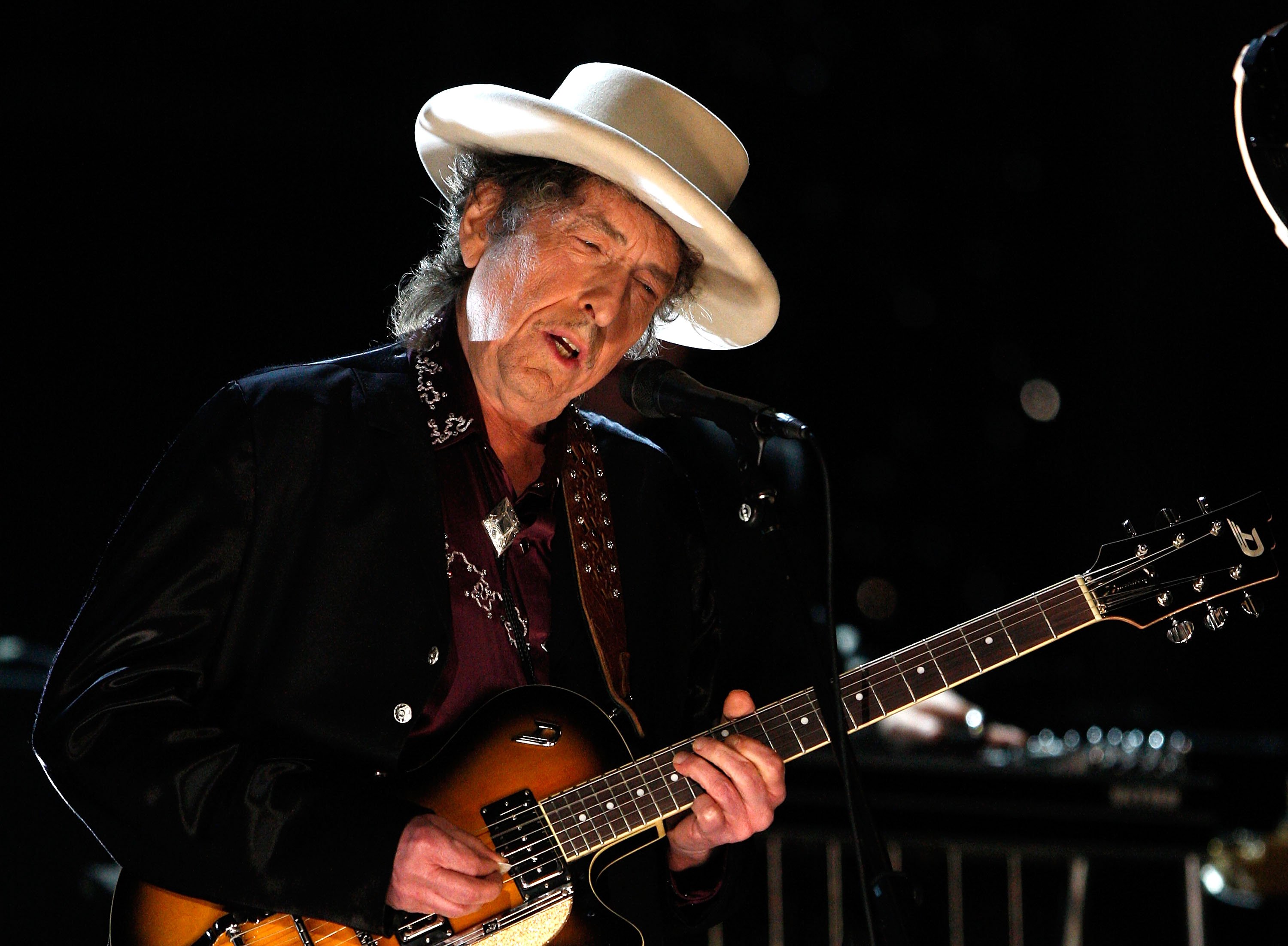 Bob Dylan plays his guitar.