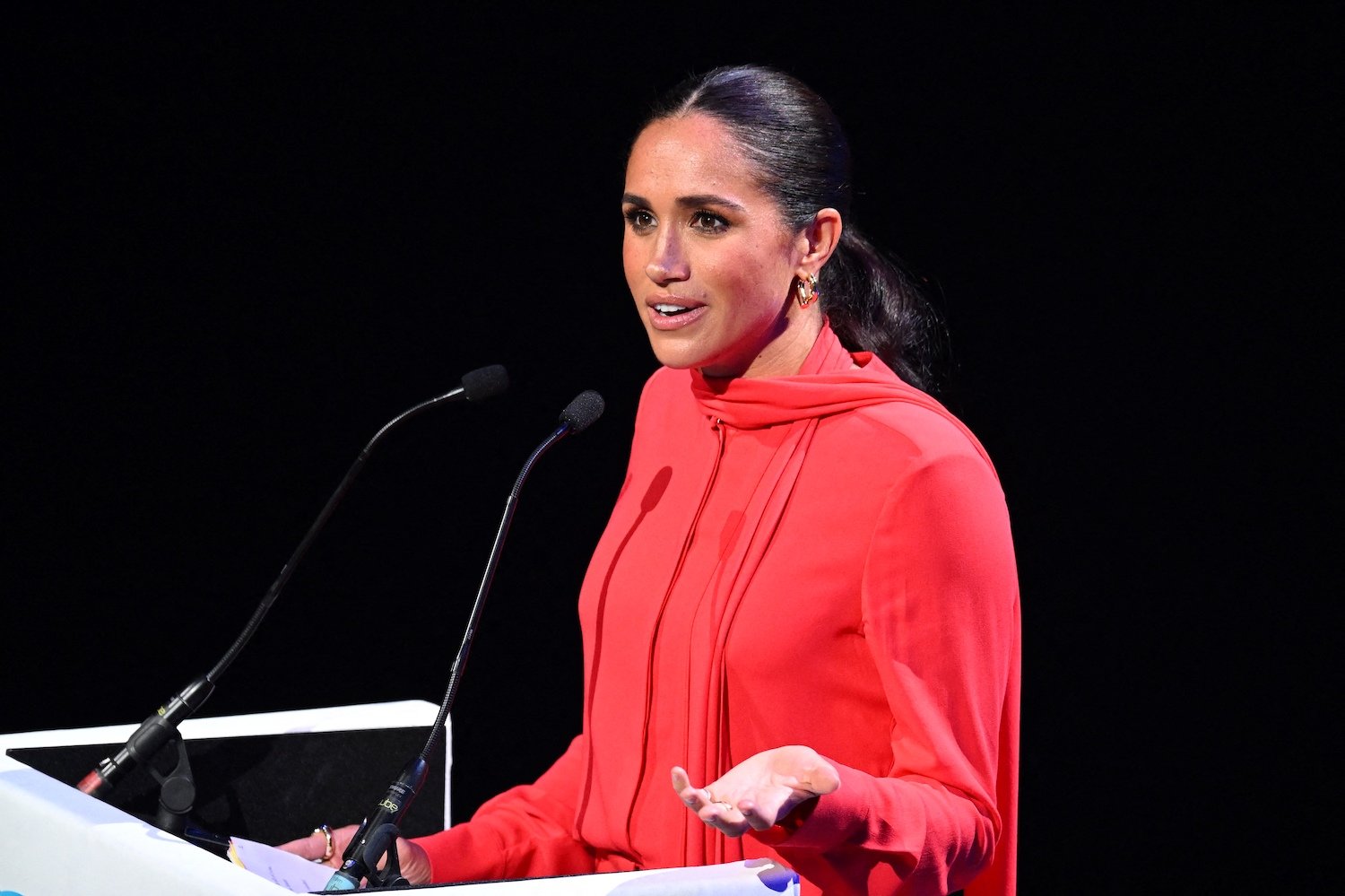 Meghan Markle delivers a speech at One Young World summit wearing a red outfit