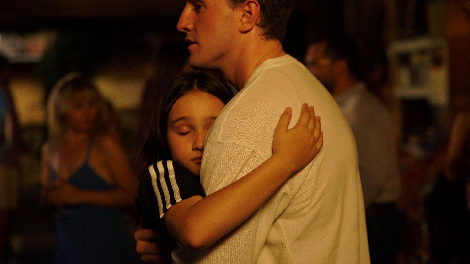 'Aftersun' Frankie Corio as Sophie and Paul Mescal as Calum hugging amidst a crowd of people.