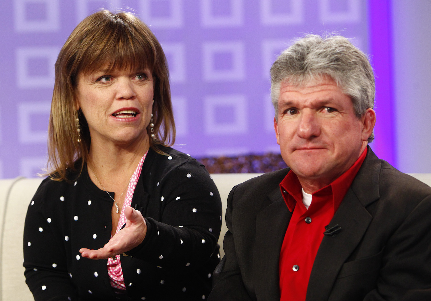 Amy Roloff and Matt Roloff from 'Little People, Big World' sitting and talking on a couch against a purple background