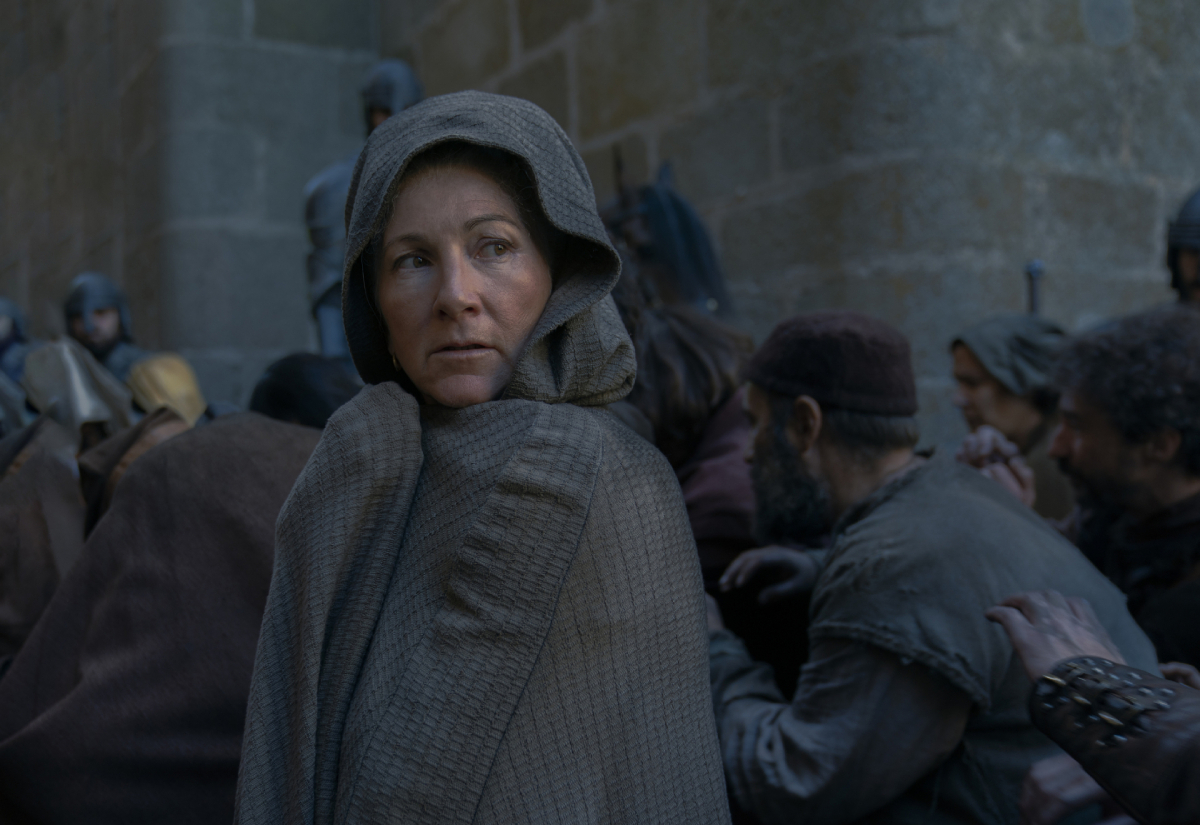 In House of the Dragon Episode 9, Rhaenys Targaryen wears a cloak and walks through the streets of King's Landing.