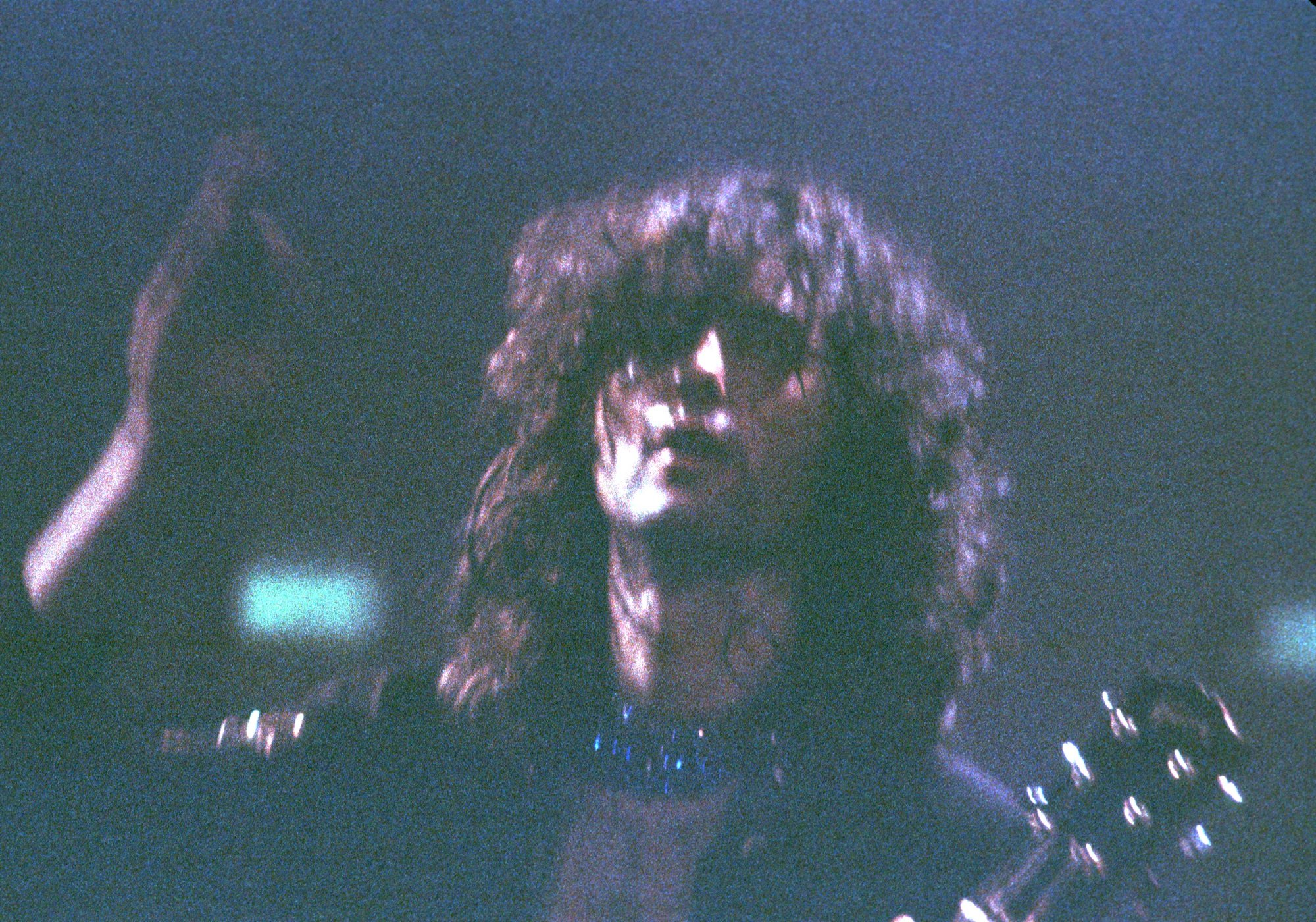 A young Jimmy Page raises his hand while on stage