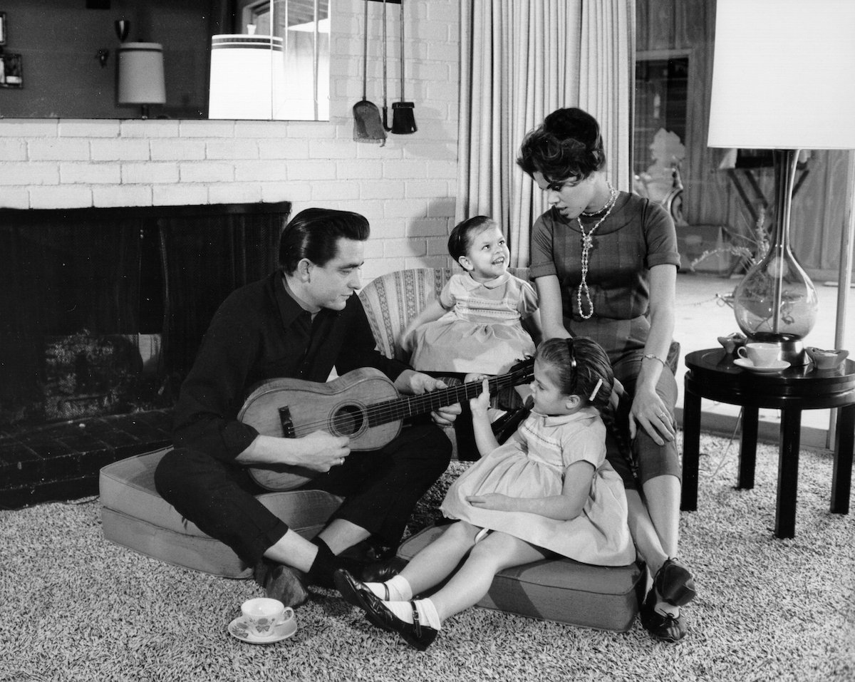 Country singer/songwriter Johnny Cash holds a guitar as his wife Vivian Liberto and daughters, Rosanne Cash and Kathy Cash, look on in 1957