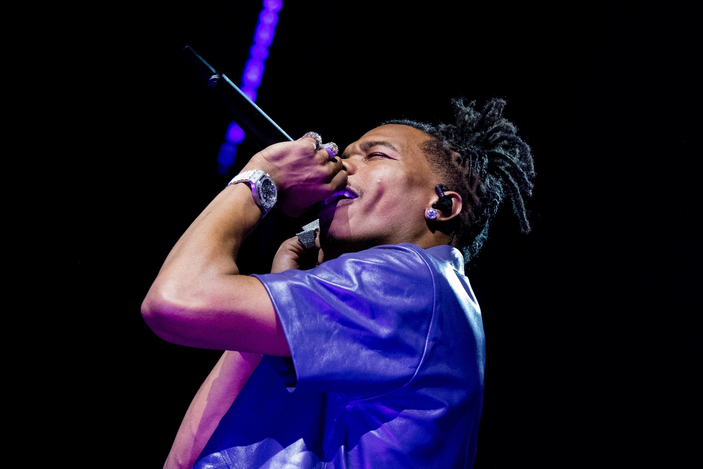 Lil Baby, who charges a steep price for a feature, performing wearing a blue jersey