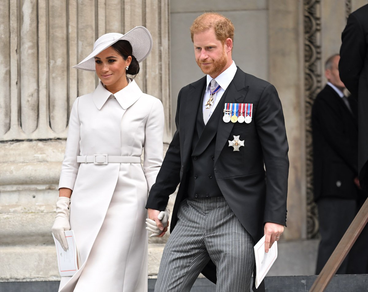 Meghan Markle and Prince Harry, whose 2020 exit from the royal family prompted a guide for private secretaries to include a question they should ask themselves, according to Valentine Low's 'Courtiers' book, hold hands outside St. Paul's Cathedral