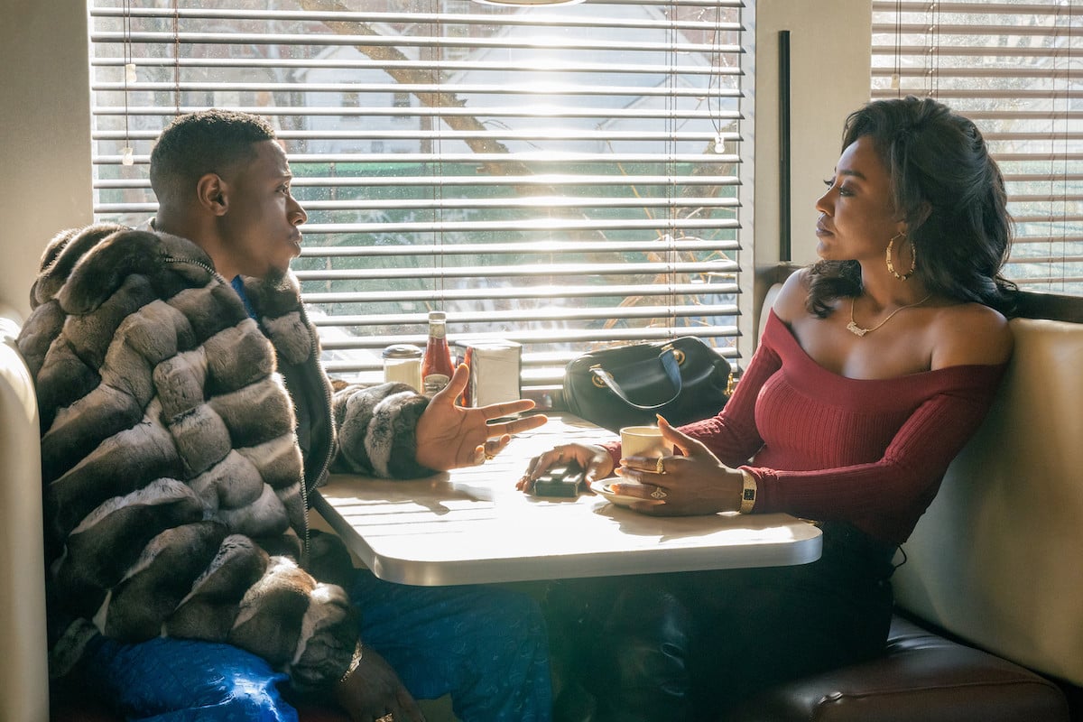 Joey Bada$$ as Unique and Patina Miller as Raq sitting in a diner booth having a conversation in 'Power Book III: Raising Kanan'