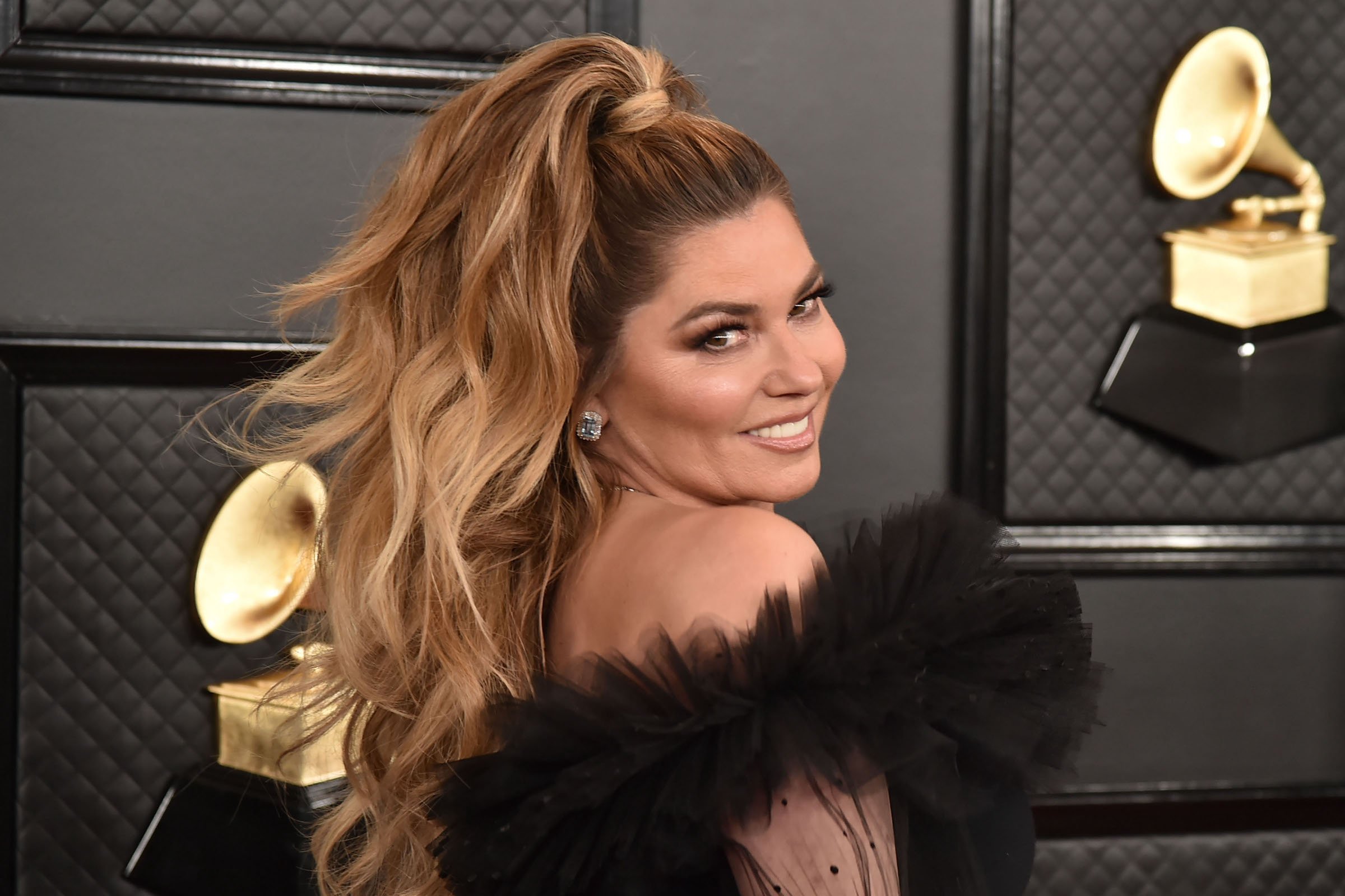 Shania Twain, who was inspired by drag queens to write one of her biggest hits, smiling for a photo at the Grammys wearing black