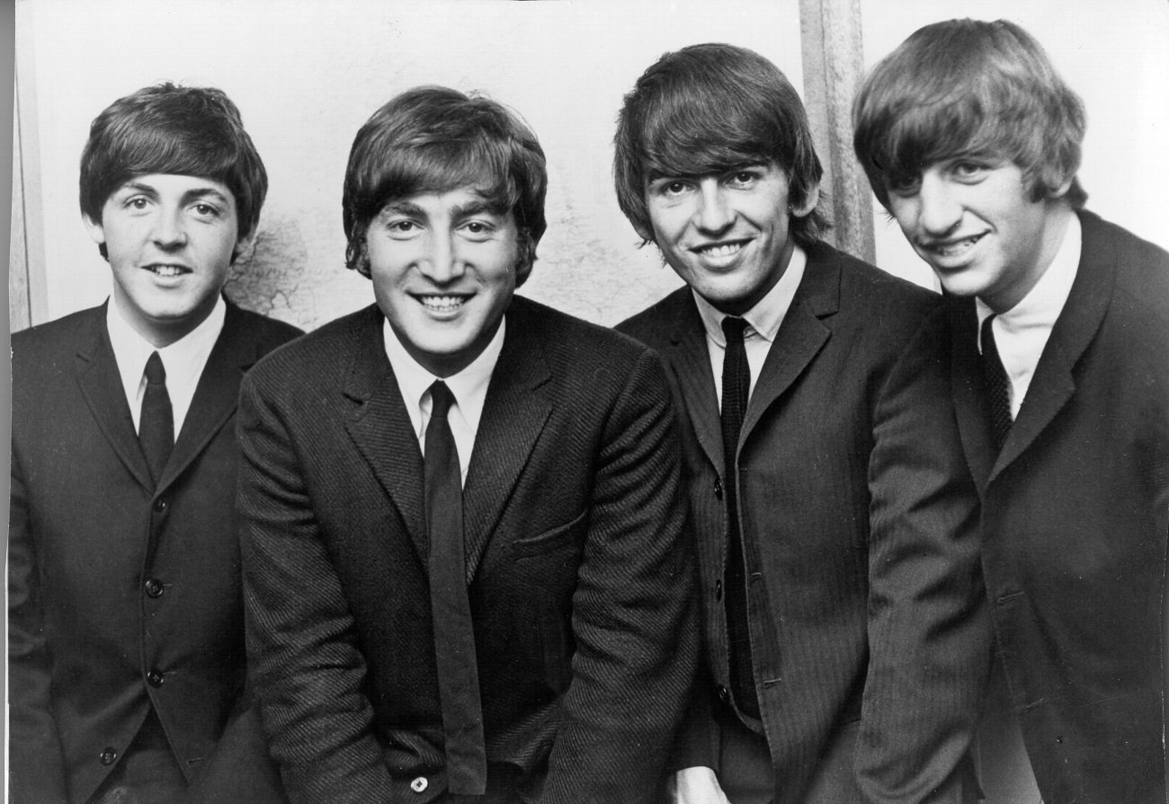 A black and white picture of Paul McCartney, John Lennon, George Harrison, and Ringo Starr of The Beatles wearing suits.