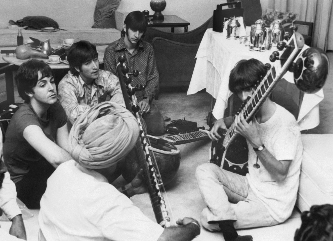 George Harrison playing the sitar in front of The Beatles in 1966.