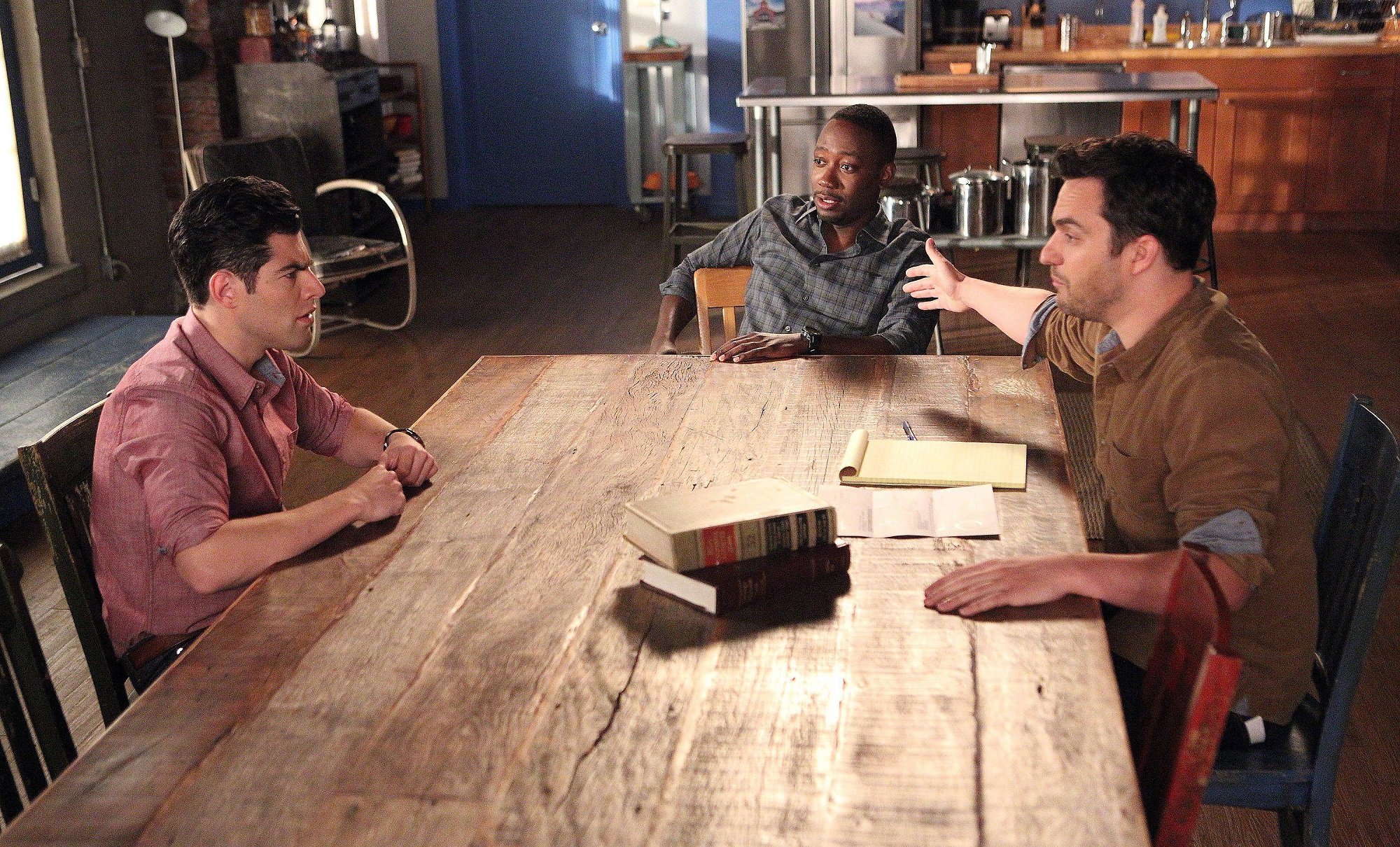 Max Greenfield, Lamorne Morris and Jake Jonson in 'New Girl' as Nick Schmidt, and Winston sitting at a table and talking.