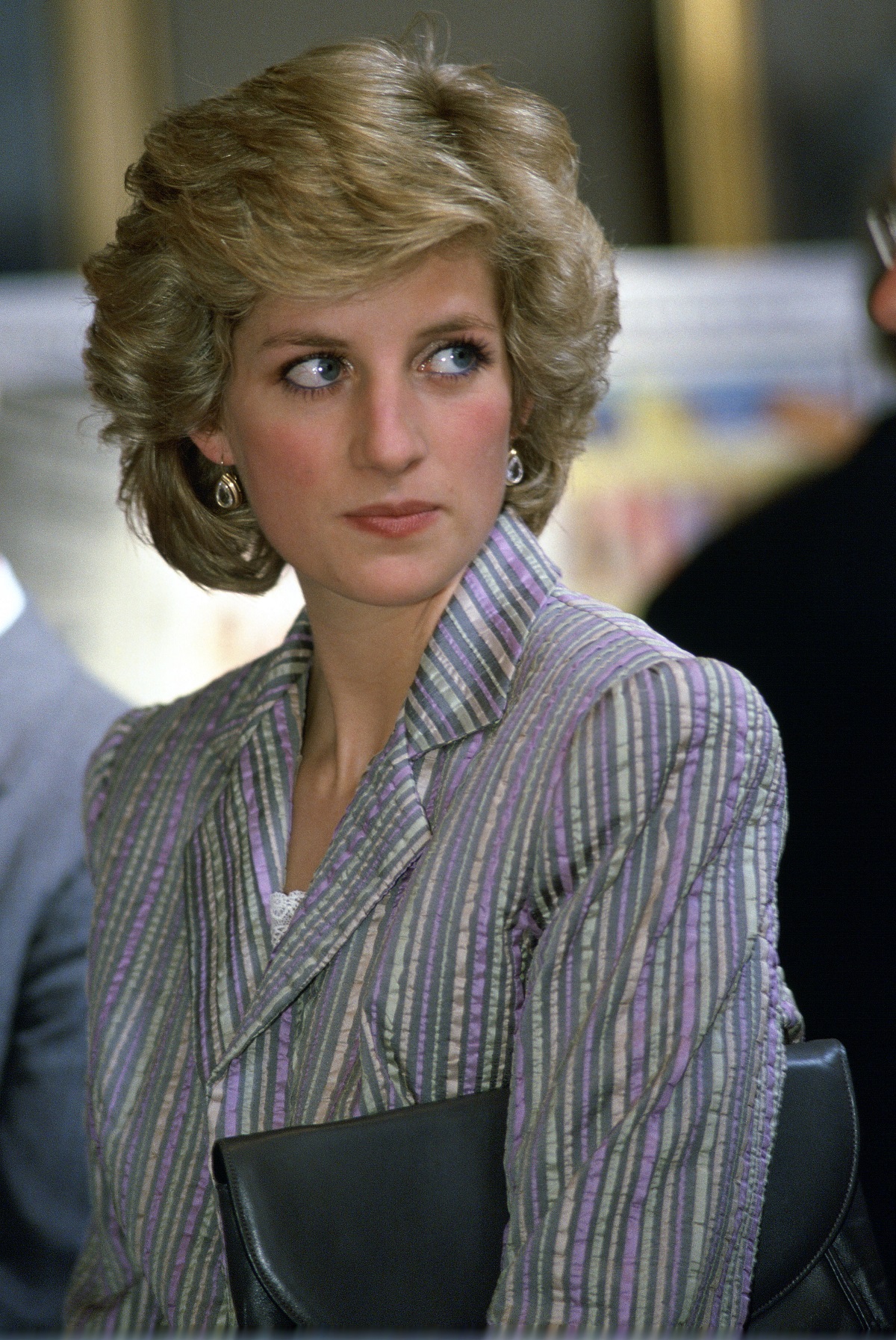 Princess Diana holding her bag under her arm and wearing a suit at the Charity Birthright in Regent's Park in London