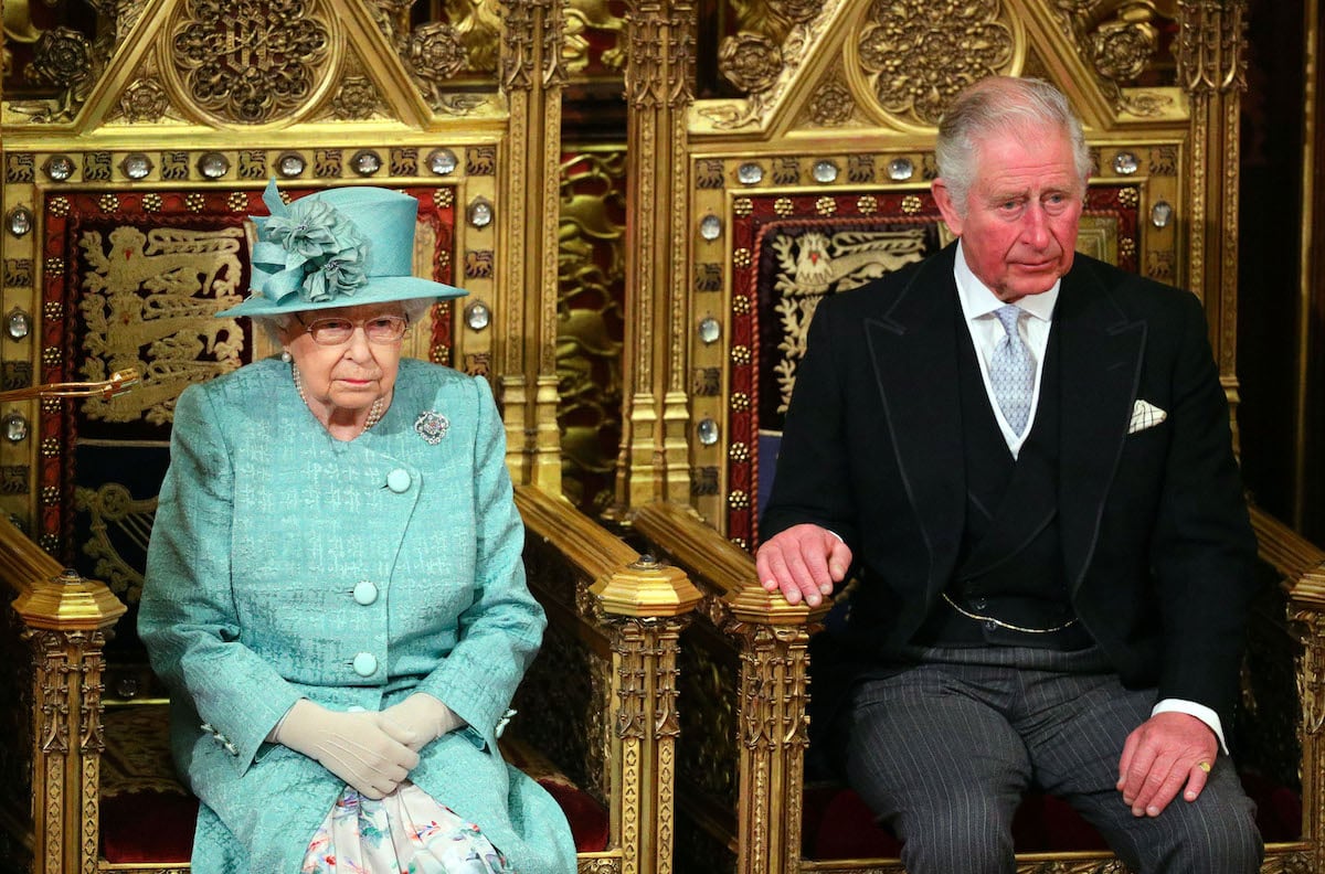 Queen Elizabeth and King Charles seated on thrones next to each other.