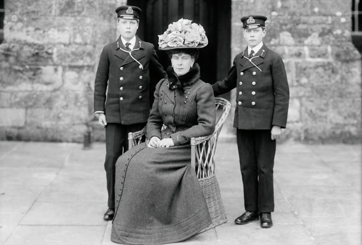 The Princess of Wales with her sons, Prince Edward (future King Edward III) and Prince Albert (future King George VI), in front of the Queen's Entrance to Barton Manor, Isle of Wight, 1909. The future Queen Mary (1867-1953) with her sons in naval cadets' uniforms. 