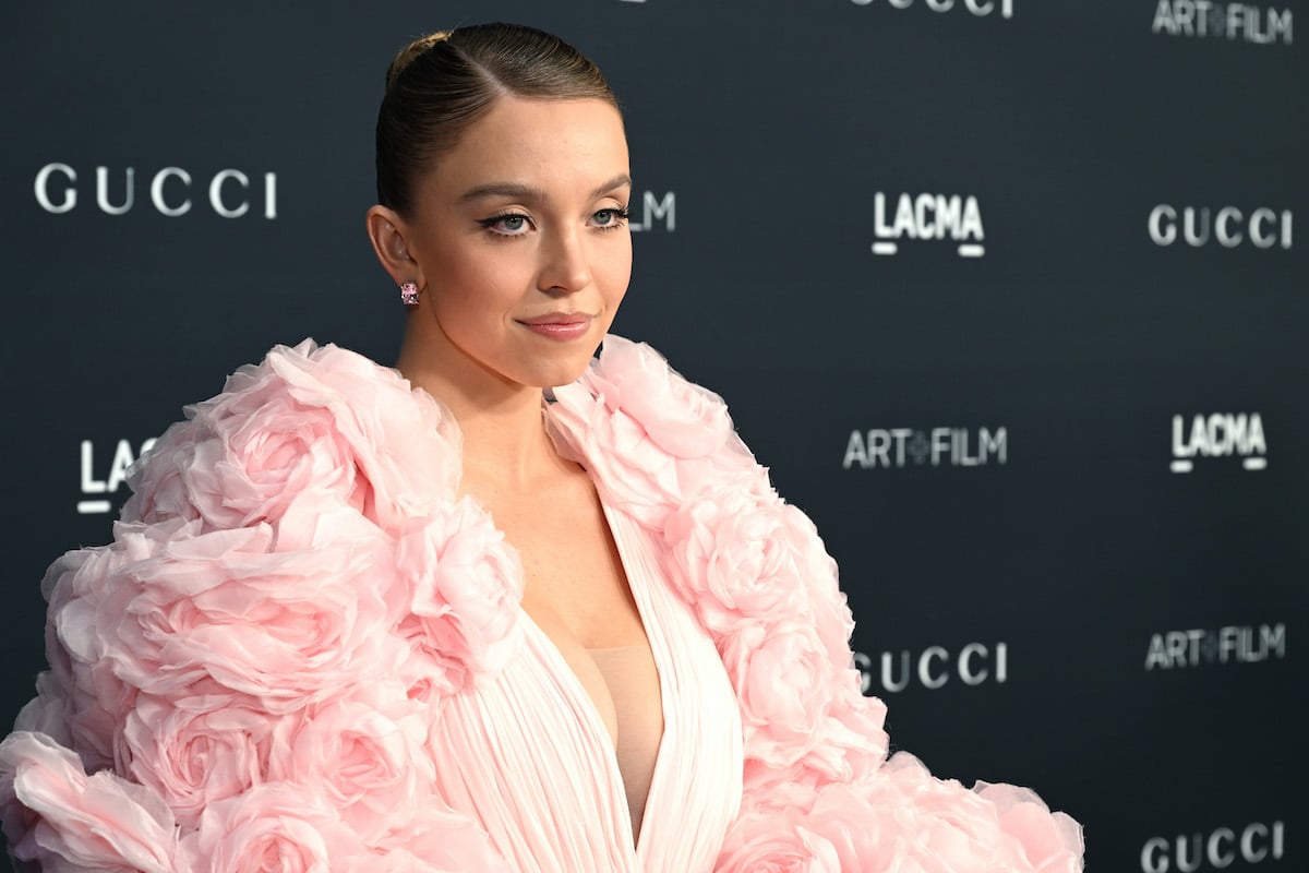 Sydney Sweeney wears a pink gown and smirks for the camera