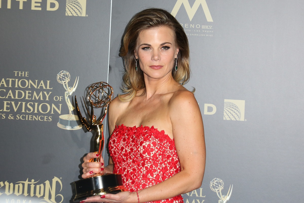 'The Young and the Restless' star Gina Tognoni wearing a red dress and holding a Daytime Emmy.