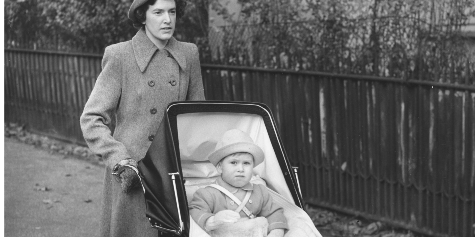 Then-Prince Charles being pushed in a stroller by his nanny Mabel Anderson.