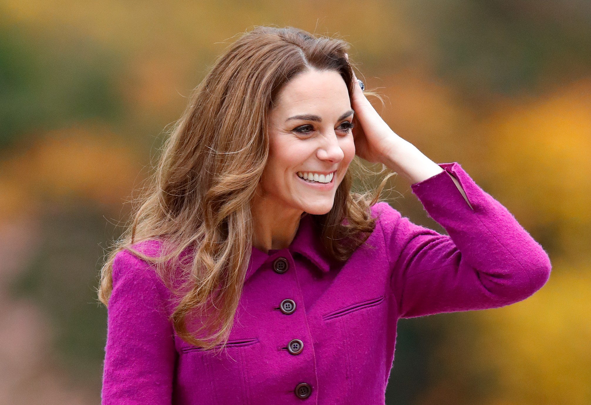 Kate Middleton touches her hair and smiles during an event at 'The Nook' Children's Hospice.