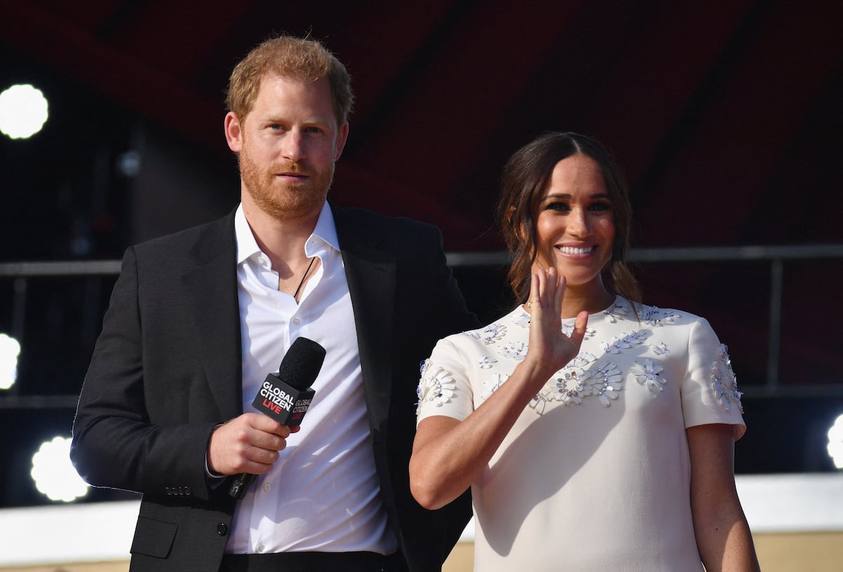 Prince Harry and Meghan Markle, who have trouble in their relationship with the royal family, stand together at an event.