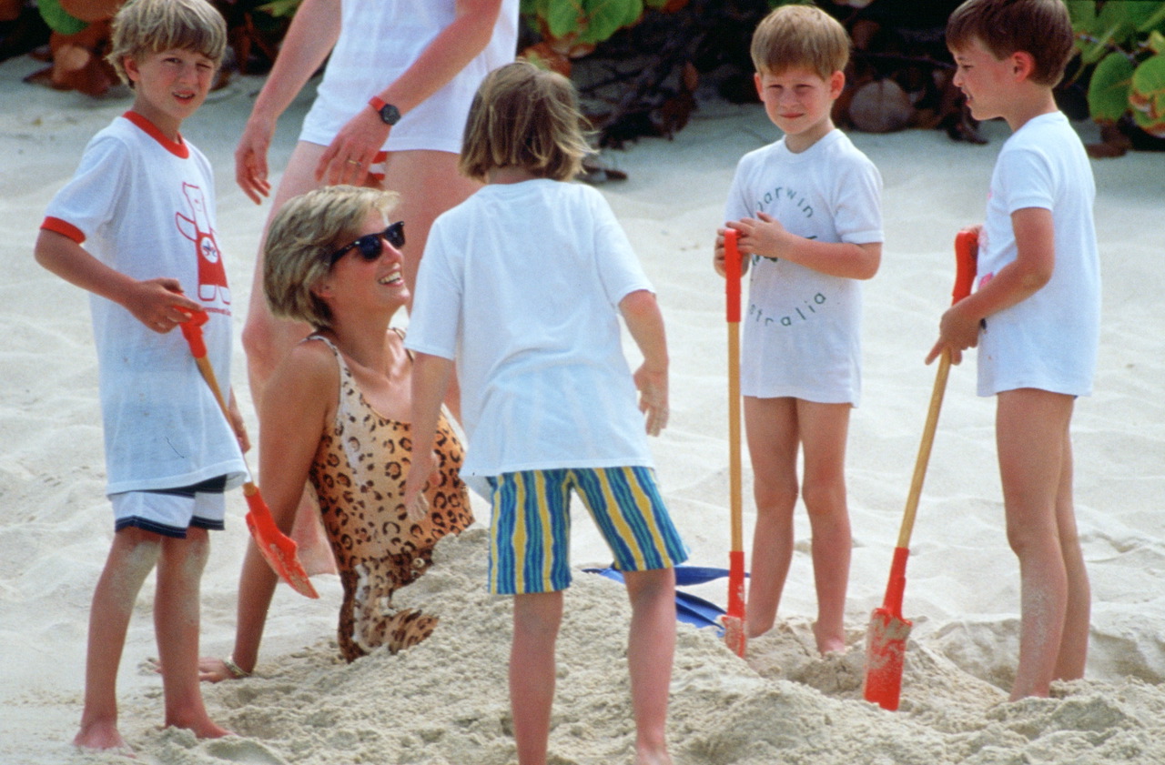 Princess Diana pictured while being buried in the sand by her sons, Prince William and Prince Harry, during a holiday on Necker Island.